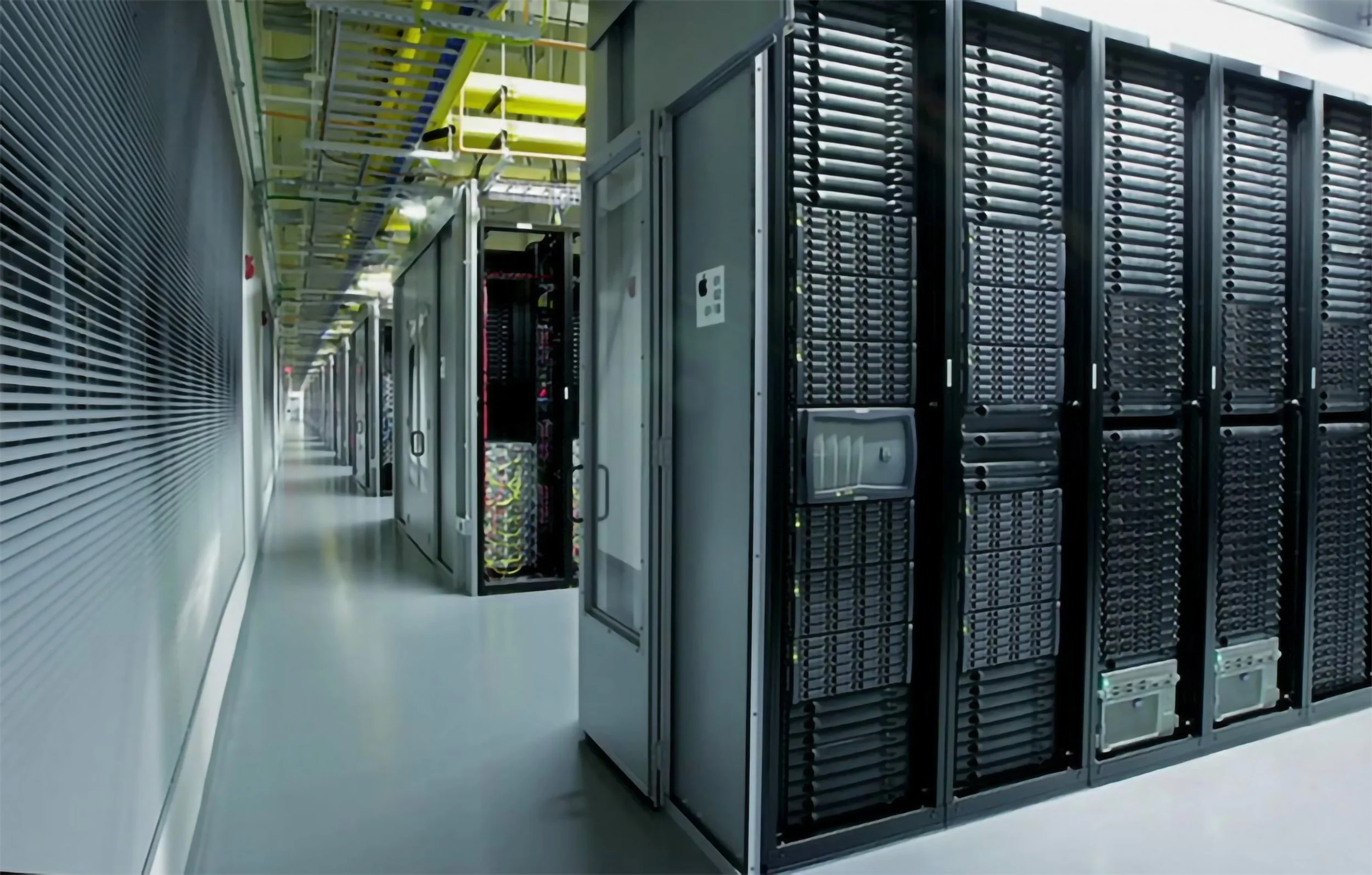 High-density server rack aisle in a hyperscale data center with overhead cable management and cooling distribution.