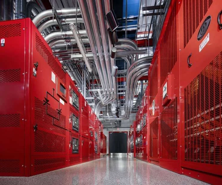 Row of high-capacity cooling units with integrated piping and electrical systems in a large-scale data center facility.