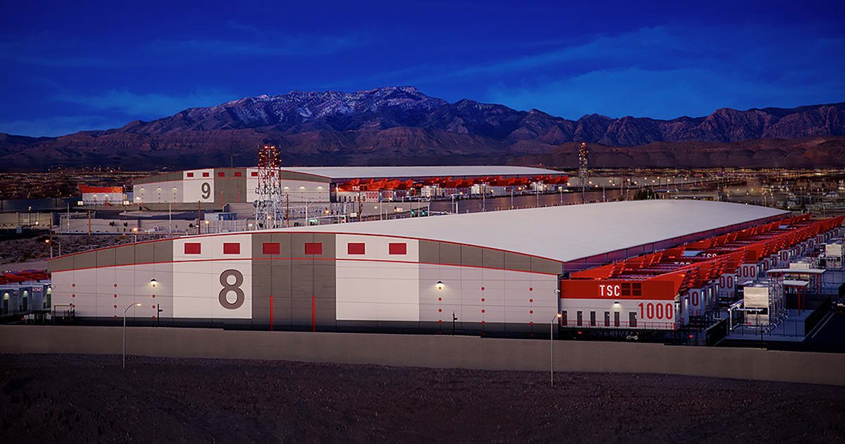 high-density data center facility exterior in a desert landscape with mountains in the background.