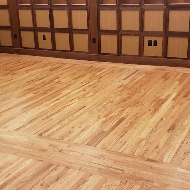 Empty room with wooden flooring and paneled wood wall.