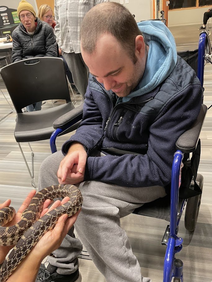  A SOAR friend petting a snake at one of our Naturalist Nights at Westwood Hills Nature Center