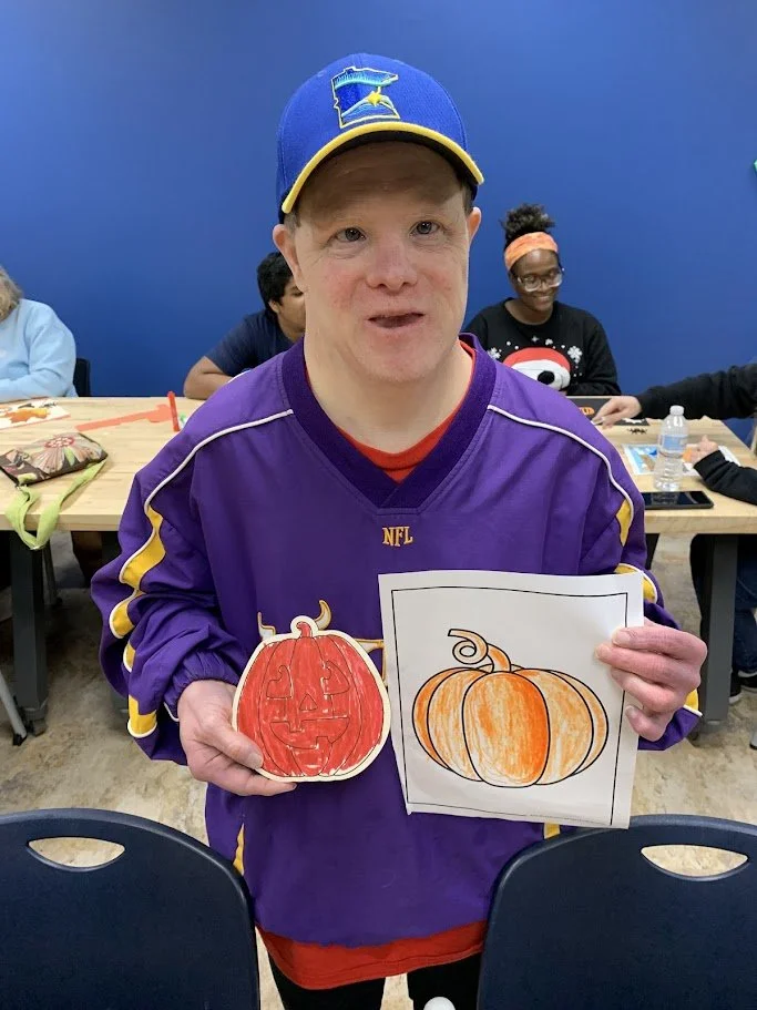 A SOAR friend showing off some Fall themed pumpkin art at a Craft and Chat Class Fall 2025