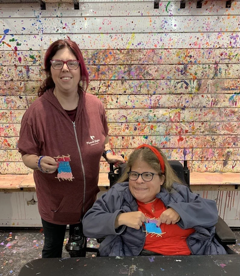 2 SOAR friends showing off their weaving art project they made at one of our Art without Limits Studio Sessions at Mess Hall Arts Fall 2025