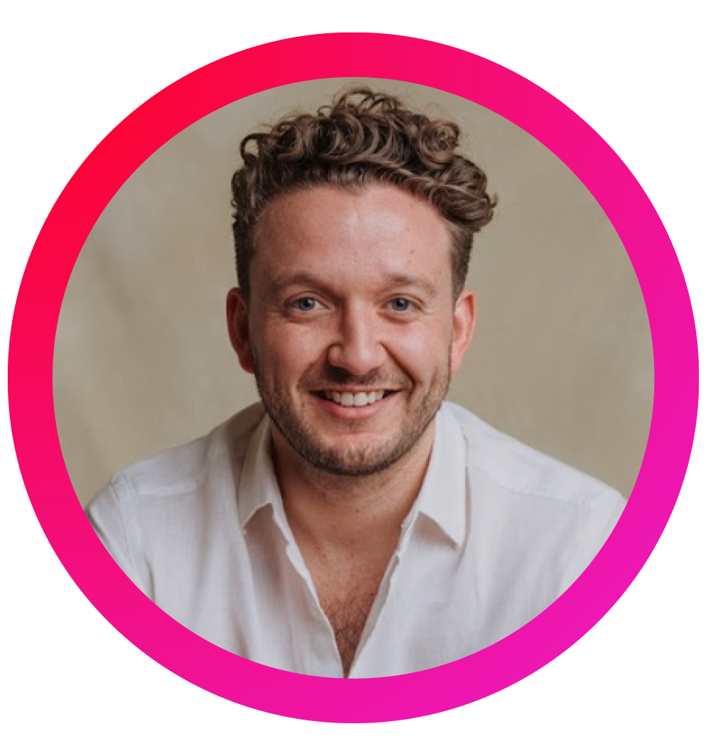 Retrato de un hombre con cabello rizado, barba y sonrisa, usando una camisa blanca, fondo neutro