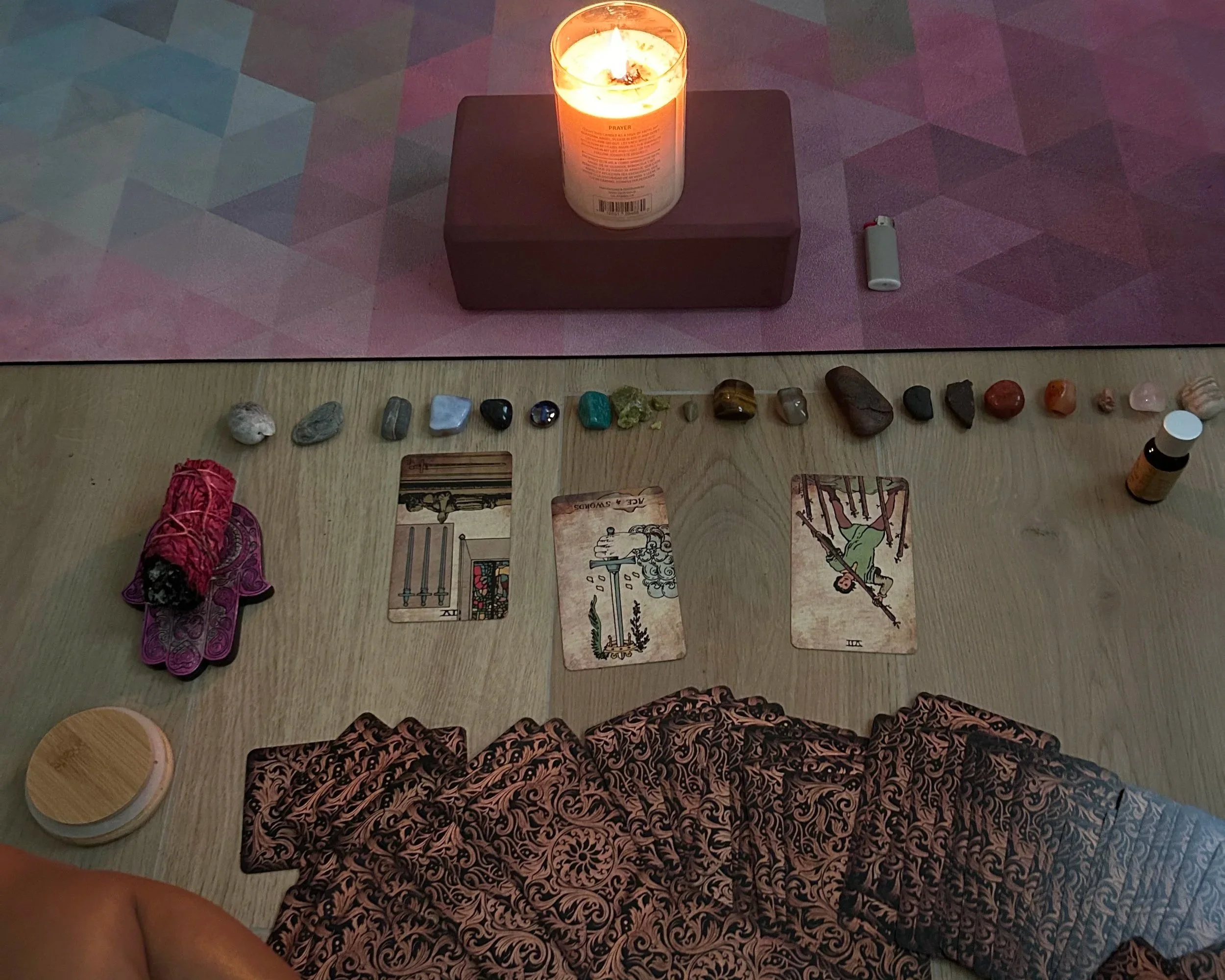 Tavolo con carte dei tarocchi, cristalli e candele, atmosfera suggestiva