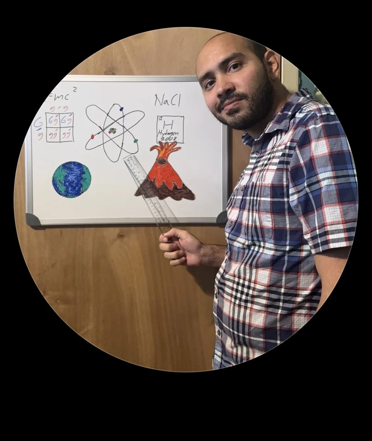 A man in a plaid shirt holding a ruler in front of a whiteboard, which has drawings of the Earth, an atom, the erupting volcano Mount Hekla, a periodic table element, and the words 'NaCl' and 'Hydrogen2000'.