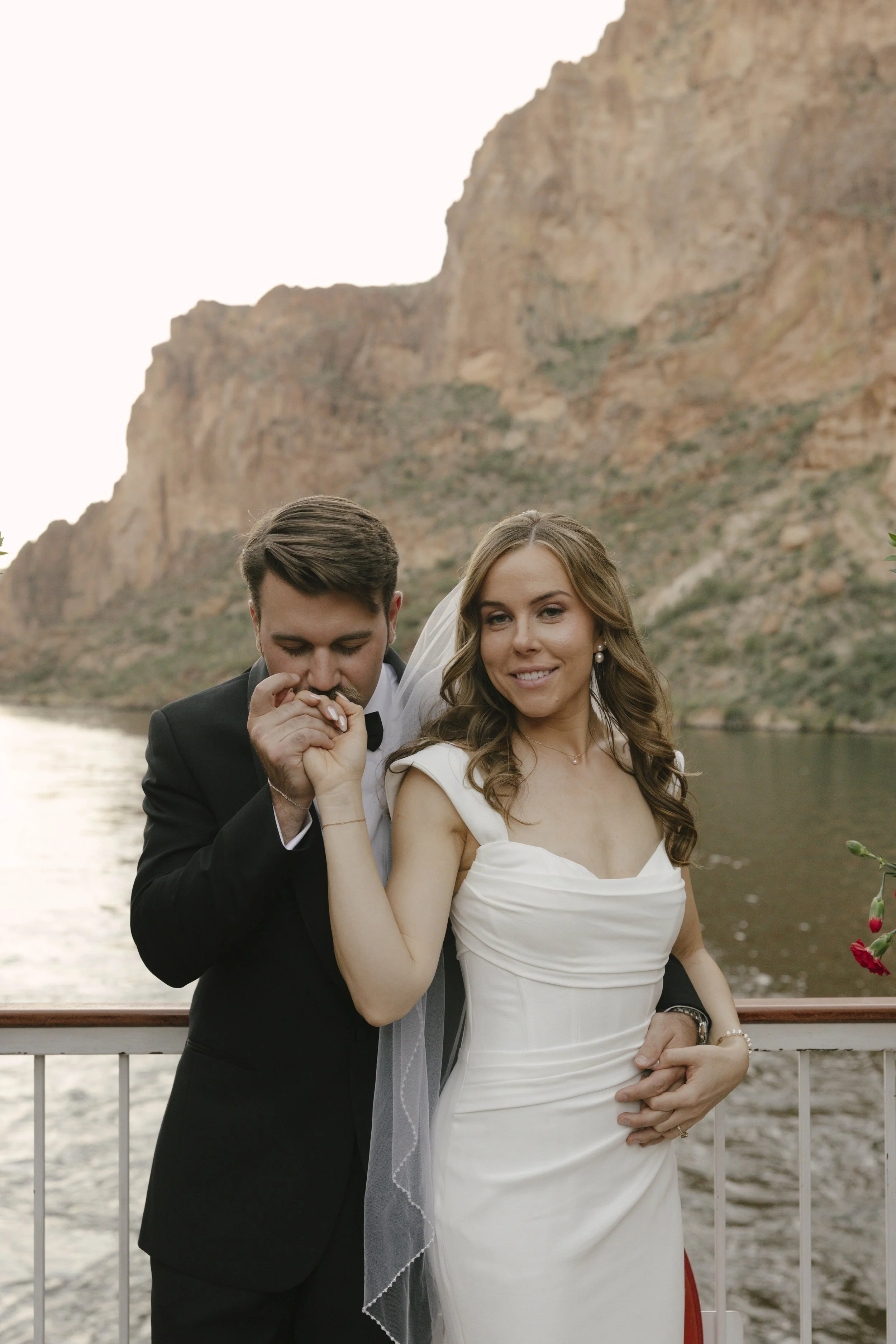 As the sun began to set over Canyon Lake, the couple stepped onto the deck of the Dolly Steamboat for golden hour portraits. With warm Arizona light reflecting off the water and desert mountains surrounding them, these quiet moments captured the beau