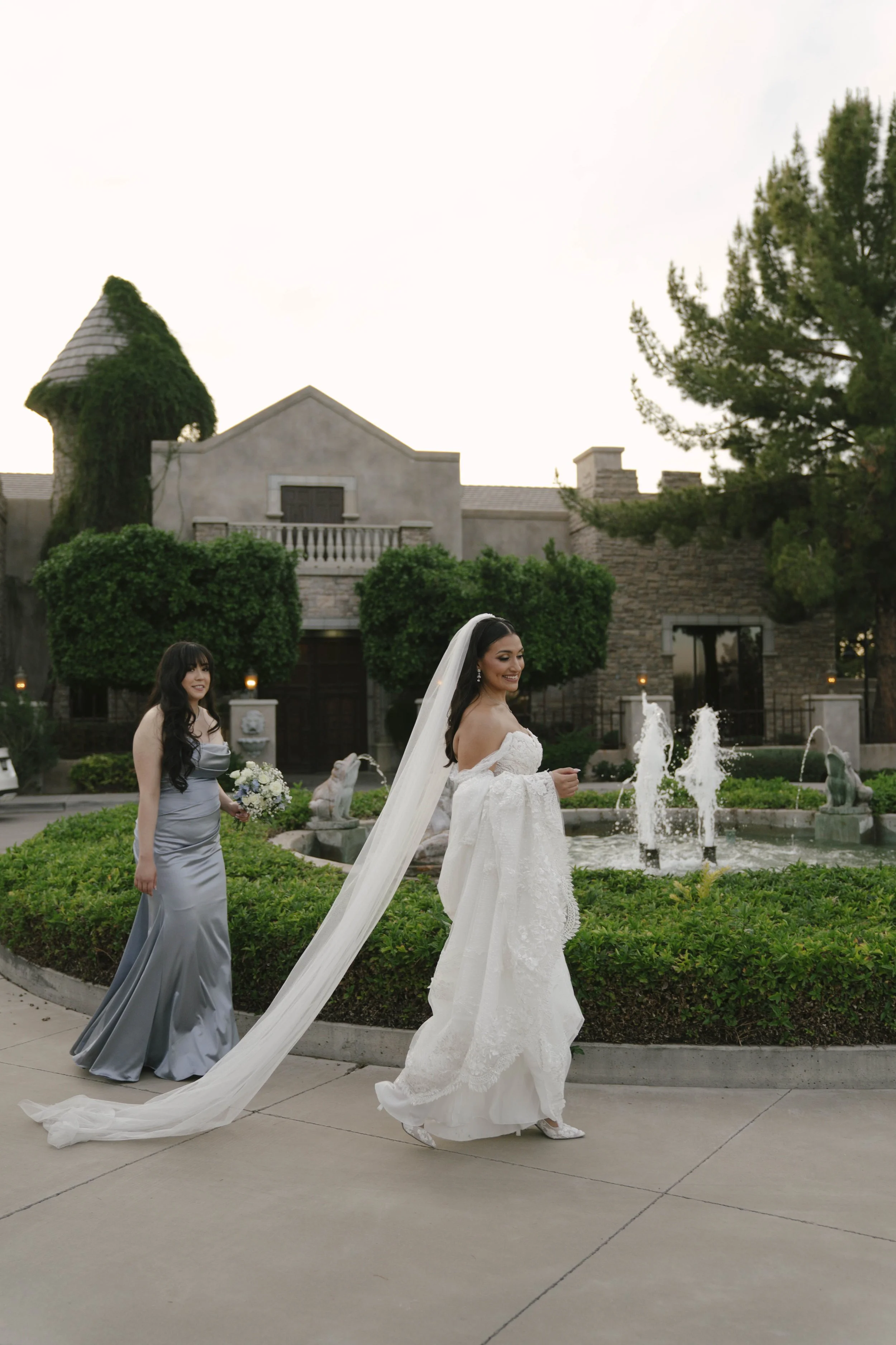 Bridal portraits at Ashley Castle in Chandler, Arizona, were captured through hybrid film and digital photography, showcasing the bride’s timeless elegance alongside her bridesmaids in the castle’s romantic courtyard gardens with soft evening light a