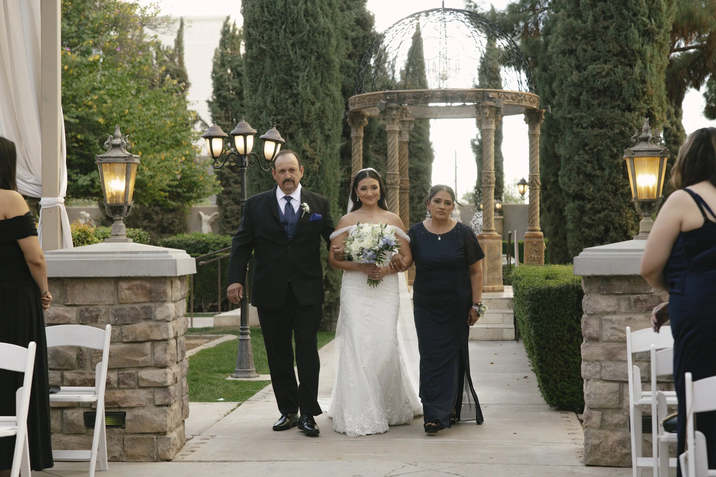 The wedding processional at Ashley Castle in Chandler, Arizona, was captured through hybrid film and digital photography, preserving the graceful entrances of the bridal party as they made their way through the romantic outdoor ceremony space surroun