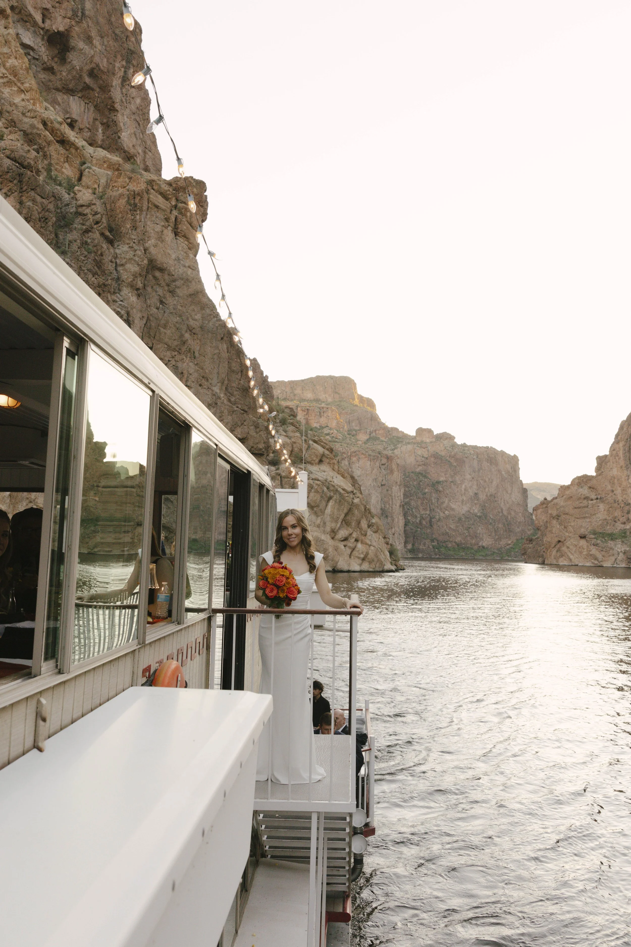 As the sun began to set over Canyon Lake, the couple stepped onto the deck of the Dolly Steamboat for golden hour portraits. With warm Arizona light reflecting off the water and desert mountains surrounding them, these quiet moments captured the beau