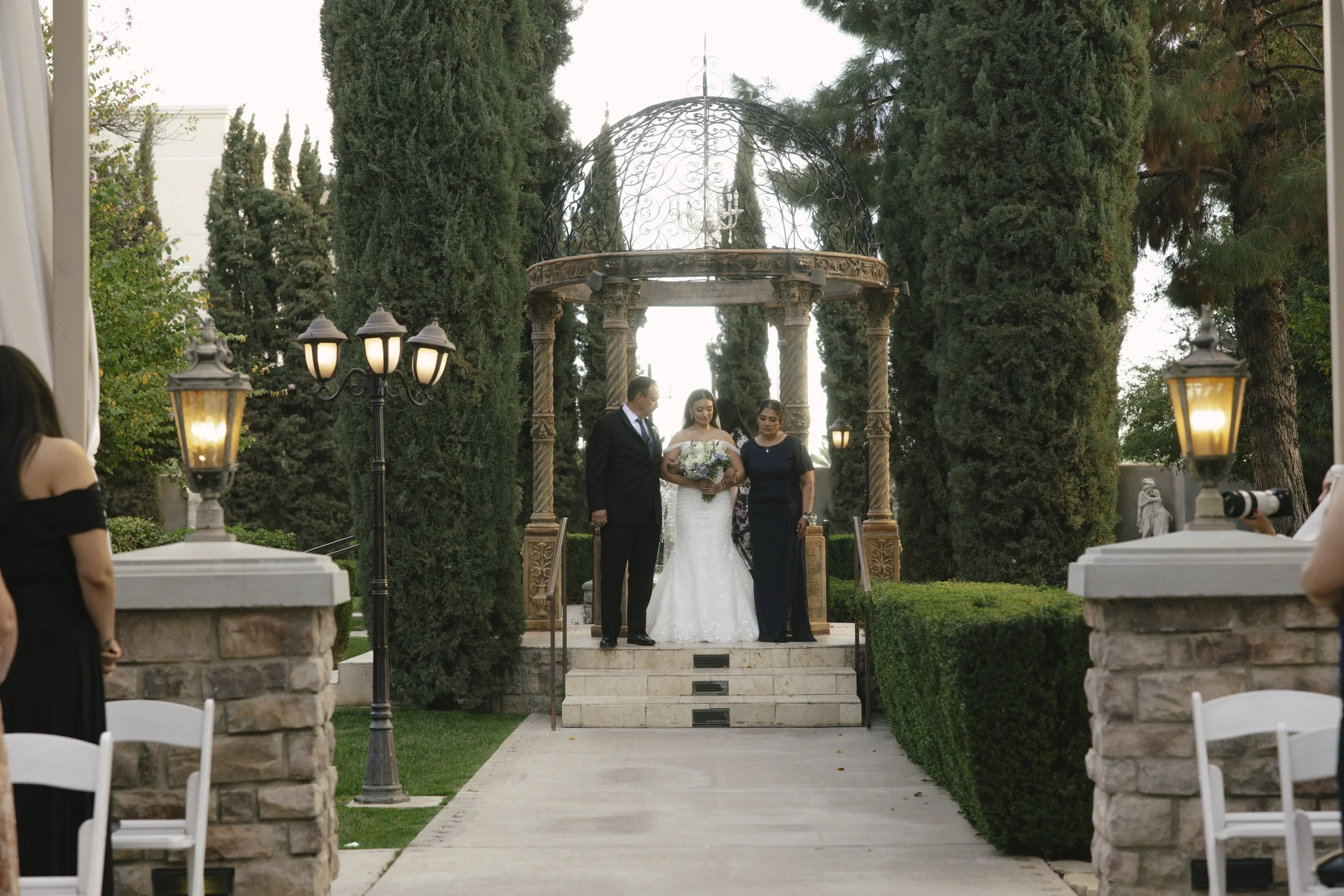 The wedding processional at Ashley Castle in Chandler, Arizona, was captured through hybrid film and digital photography, preserving the graceful entrances of the bridal party as they made their way through the romantic outdoor ceremony space surroun