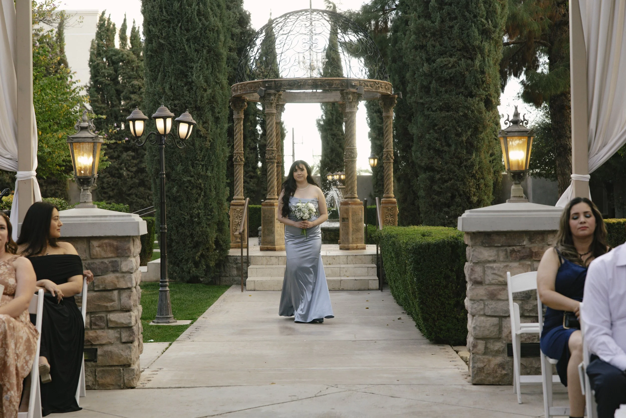 The wedding processional at Ashley Castle in Chandler, Arizona, was captured through hybrid film and digital photography, preserving the graceful entrances of the bridal party as they made their way through the romantic outdoor ceremony space surroun
