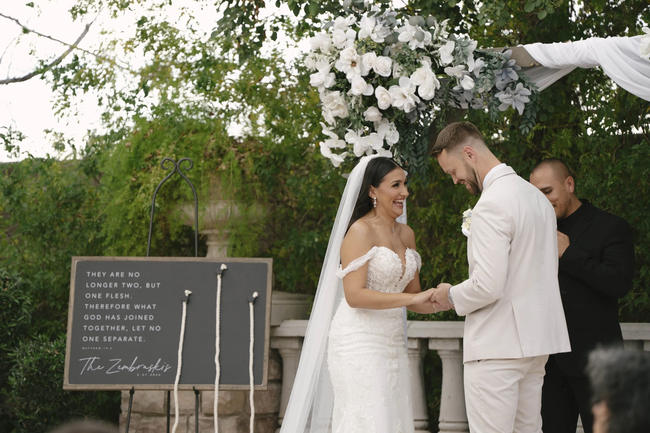 The bride and groom’s ceremony at Ashley Castle in Chandler, Arizona, was beautifully documented through hybrid film and digital photography, capturing their vows, ring exchange, and heartfelt moments beneath a romantic floral altar in the castle’s e