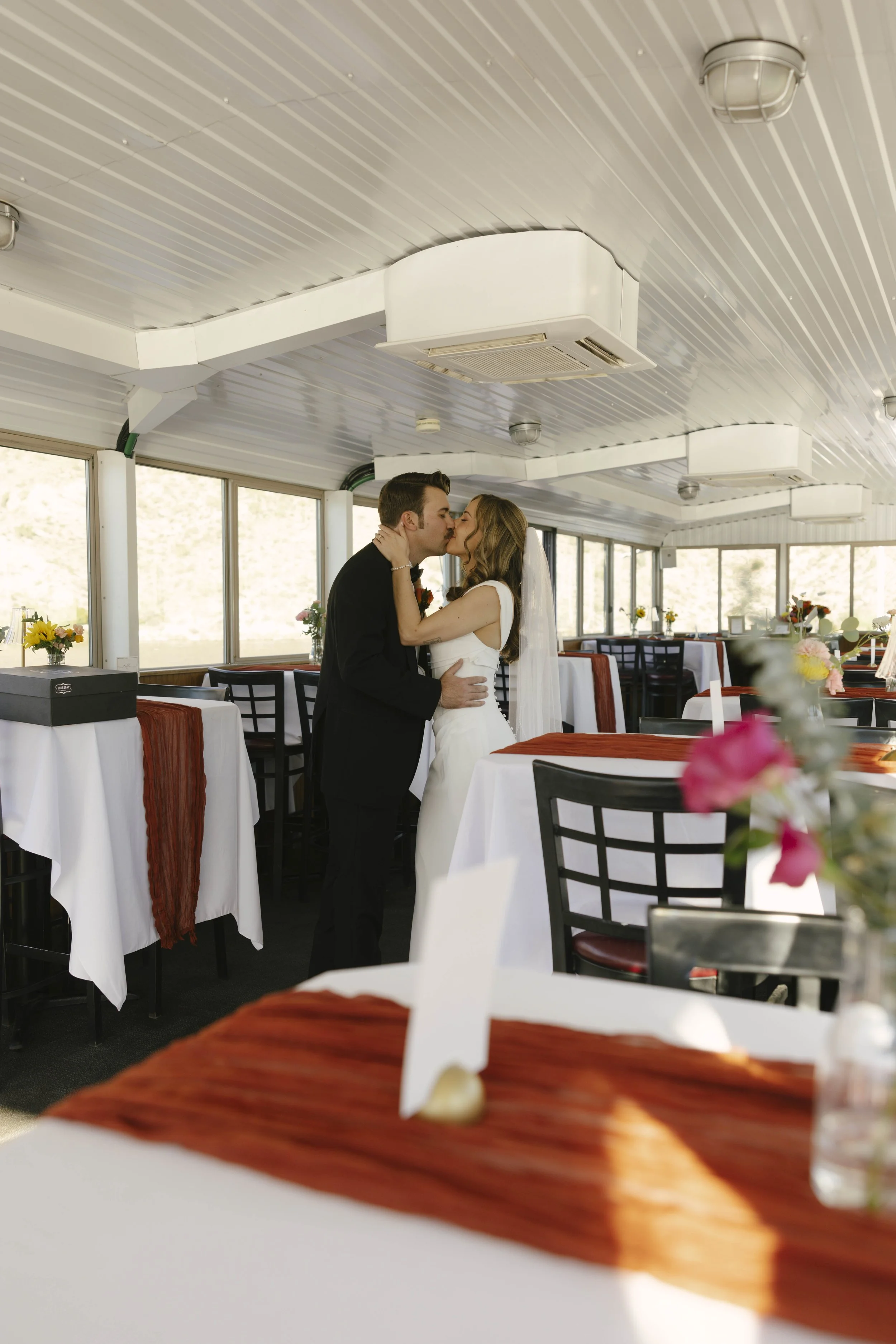 As the Dolly Steamboat cruised through Canyon Lake, guests enjoyed an intimate reception surrounded by Arizona’s desert mountains and open water. The tables were beautifully set with warm tones, fresh florals, and thoughtful details that complemented