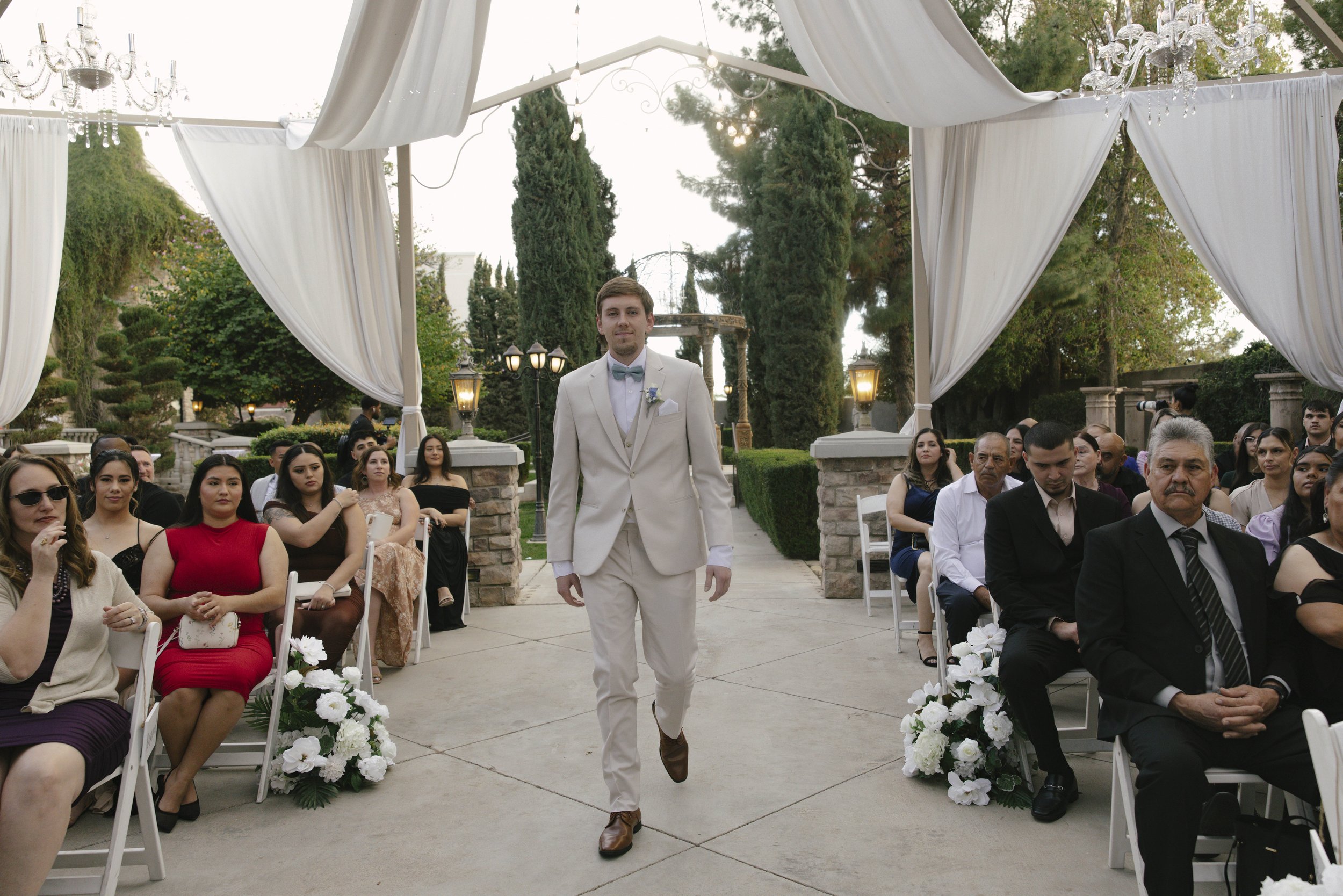 The wedding processional at Ashley Castle in Chandler, Arizona, was captured through hybrid film and digital photography, preserving the graceful entrances of the bridal party as they made their way through the romantic outdoor ceremony space surroun