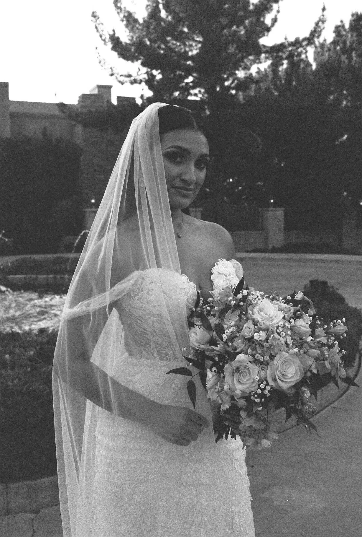 The bride’s solo portraits at Ashley Castle in Chandler, Arizona, were captured through hybrid film and digital photography, highlighting timeless bridal elegance with romantic veil details, graceful movement, and the castle’s stunning courtyard and 