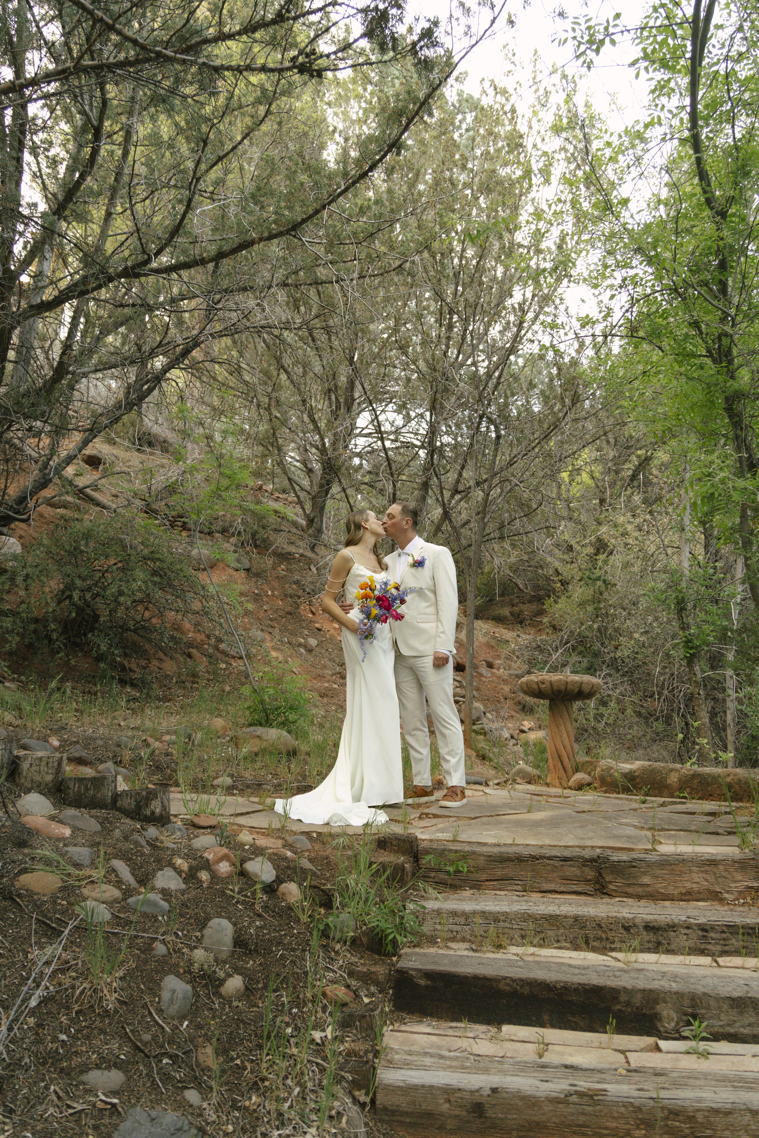 Chelsea and Travis shared an intimate first look surrounded by the natural beauty of Sedona before exchanging vows during their private Arizona elopement ceremony. Set along a peaceful garden path, these heartfelt moments marked the beginning of thei