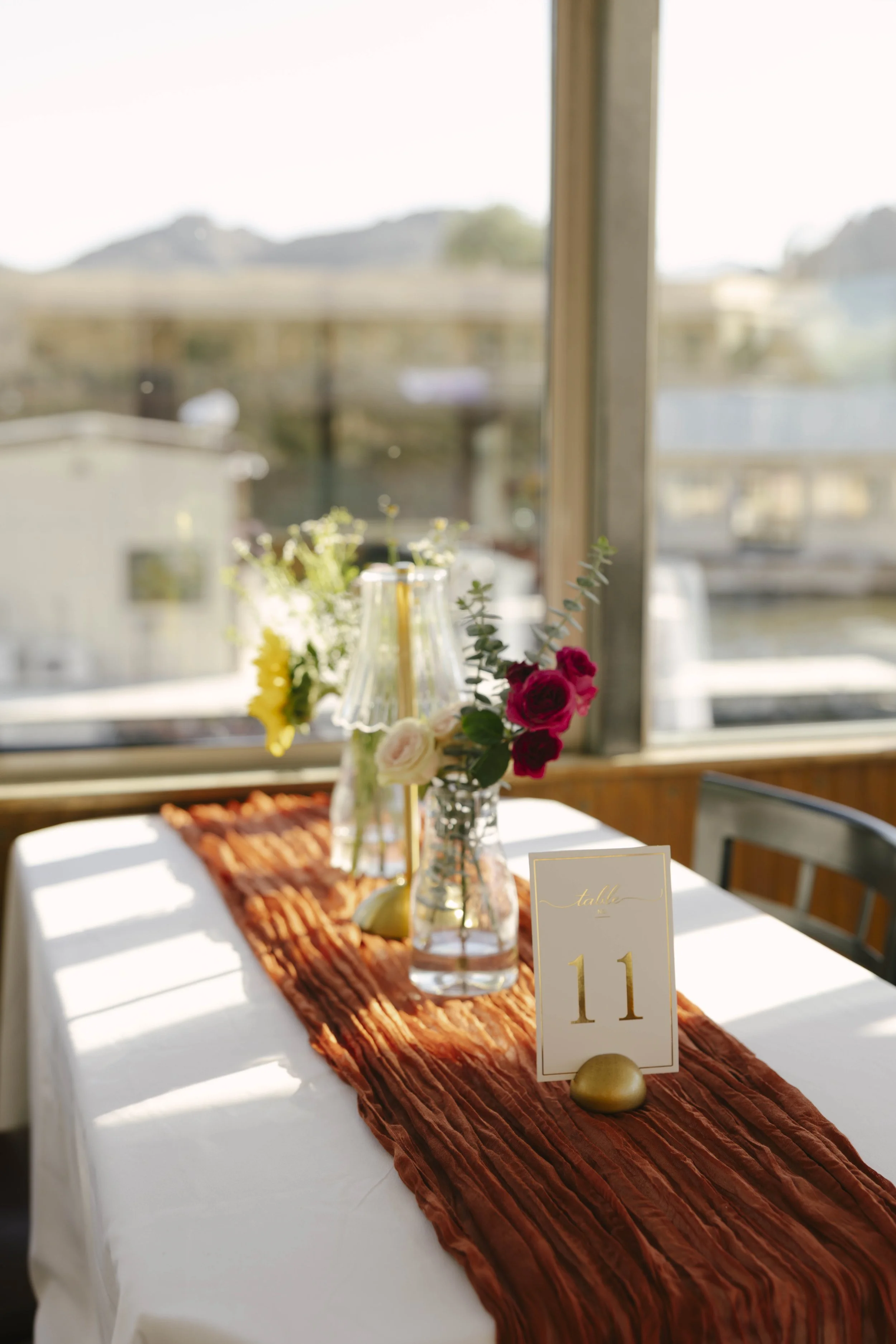 As the Dolly Steamboat cruised through Canyon Lake, guests enjoyed an intimate reception surrounded by Arizona’s desert mountains and open water. The tables were beautifully set with warm tones, fresh florals, and thoughtful details that complemented