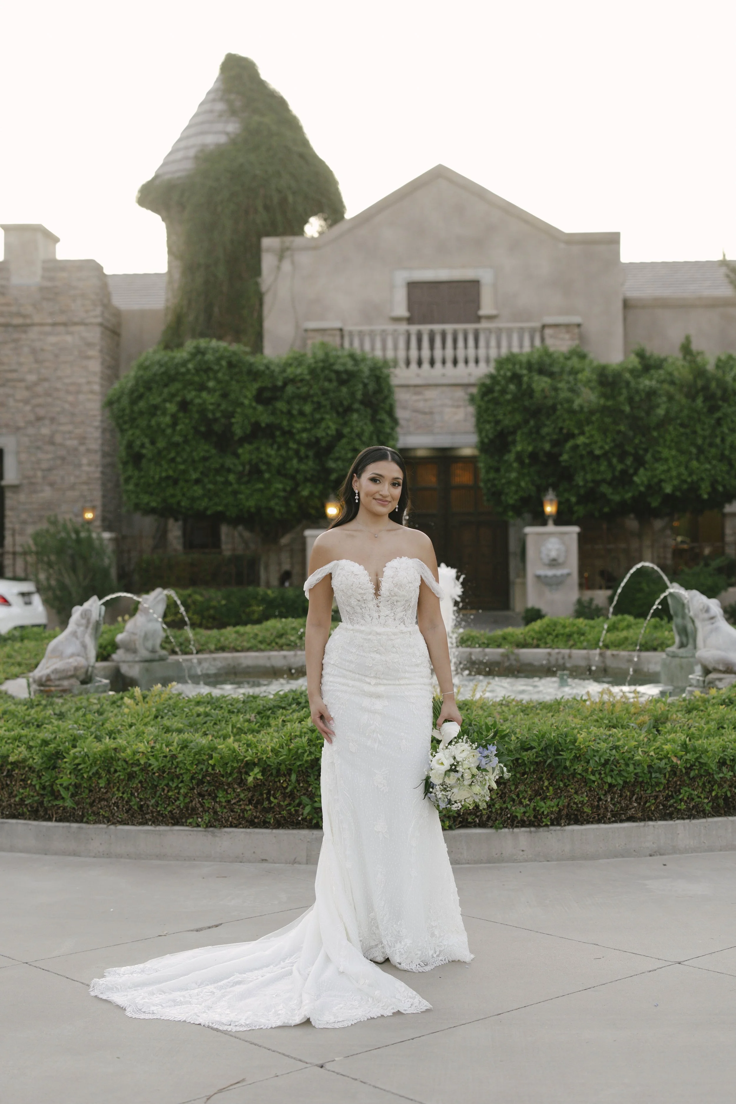 Bridal portraits at Ashley Castle in Chandler, Arizona, were captured through hybrid film and digital photography, showcasing the bride’s timeless elegance alongside her bridesmaids in the castle’s romantic courtyard gardens with soft evening light a