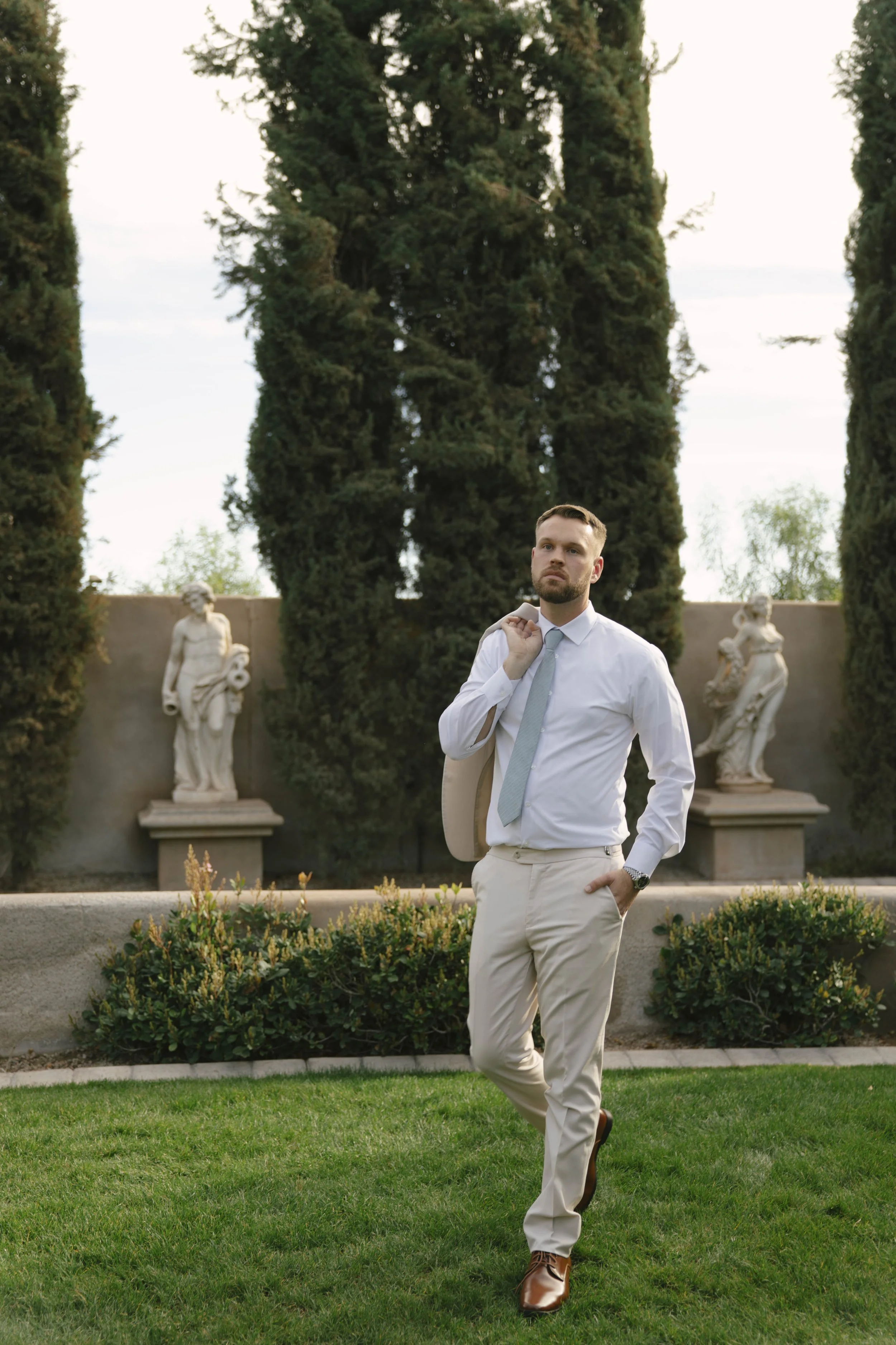 The groom’s portraits at Ashley Castle in Chandler, Arizona, were captured through hybrid film and digital photography, highlighting timeless style, refined details, and elegant garden backdrops that complement the venue’s romantic castle setting.