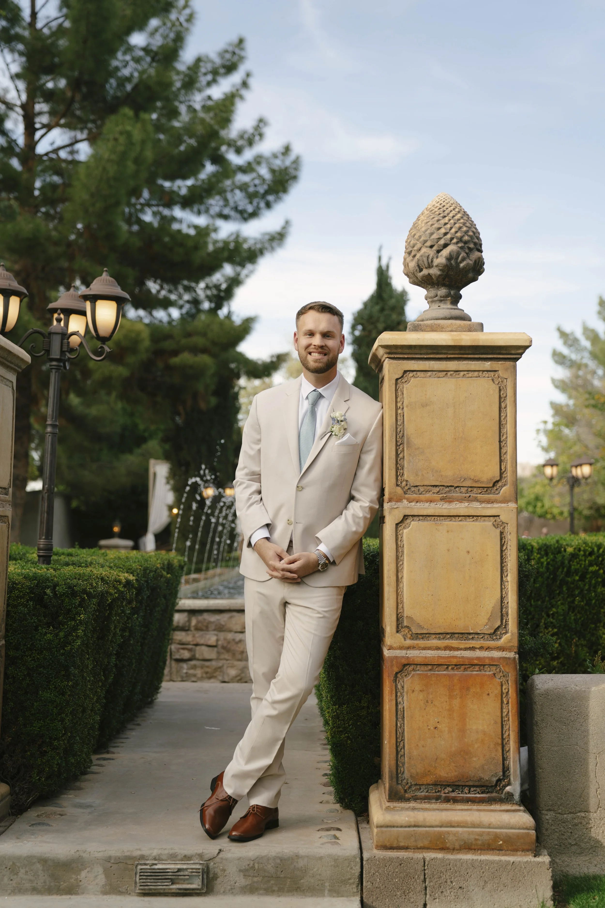 The groom’s portraits at Ashley Castle in Chandler, Arizona, were captured through hybrid film and digital photography, highlighting timeless style, refined details, and elegant garden backdrops that complement the venue’s romantic castle setting.