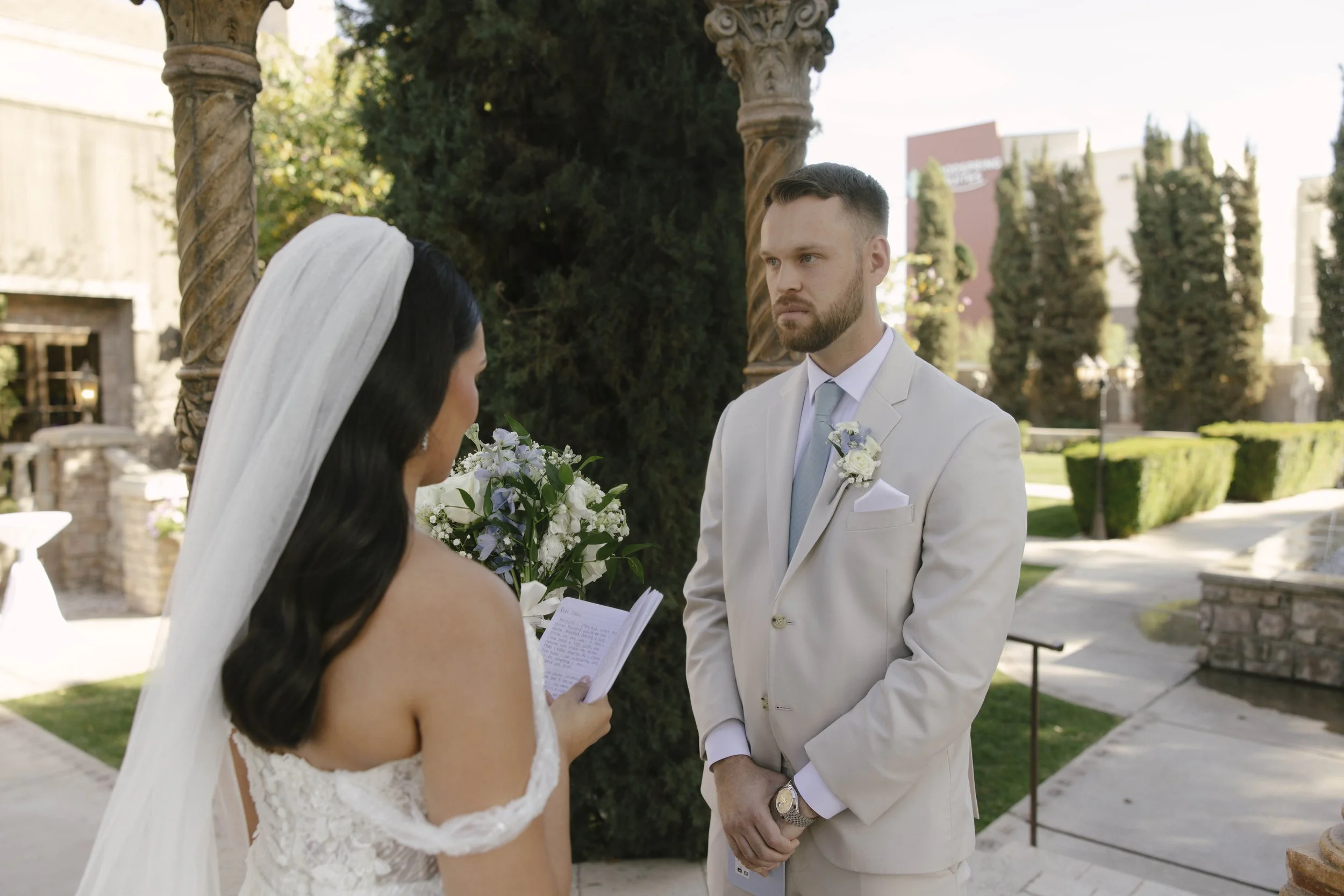 The bride and groom’s first look at Ashley Castle in Chandler, Arizona, unfolded in the venue’s romantic garden gazebo, where hybrid film and digital photography captured their emotional private reveal with timeless elegance, natural light, and intim