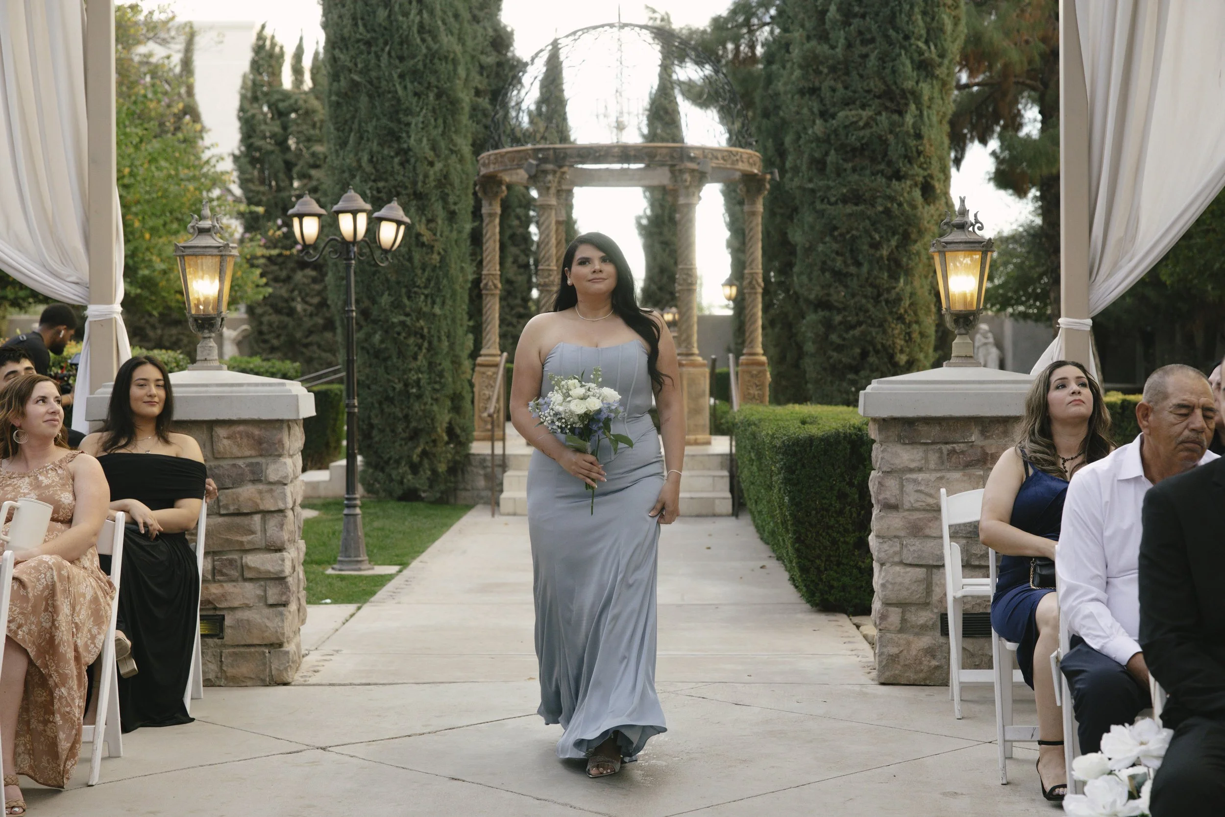 The wedding processional at Ashley Castle in Chandler, Arizona, was captured through hybrid film and digital photography, preserving the graceful entrances of the bridal party as they made their way through the romantic outdoor ceremony space surroun