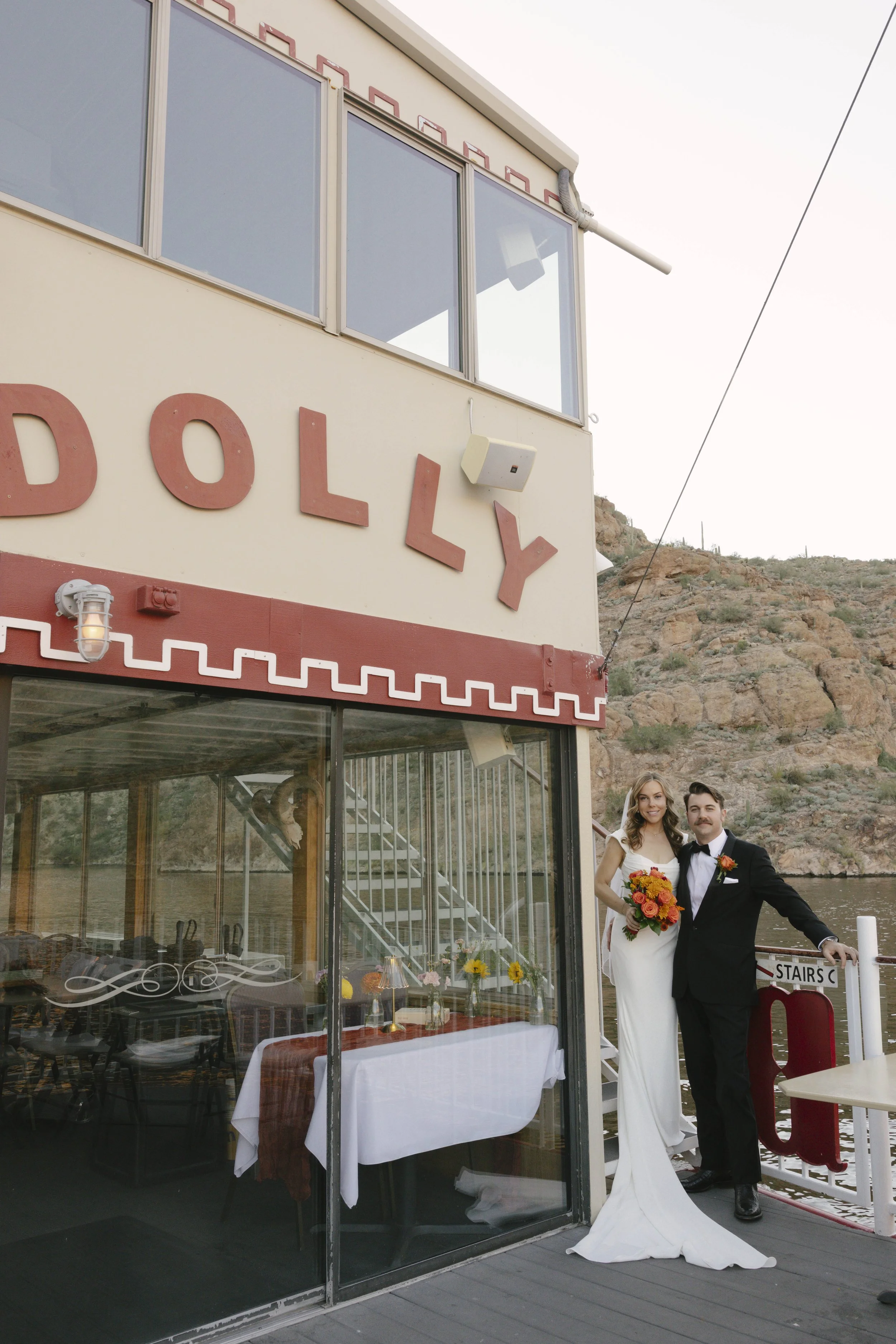 As the sun began to set over Canyon Lake, the couple stepped onto the deck of the Dolly Steamboat for golden hour portraits. With warm Arizona light reflecting off the water and desert mountains surrounding them, these quiet moments captured the beau