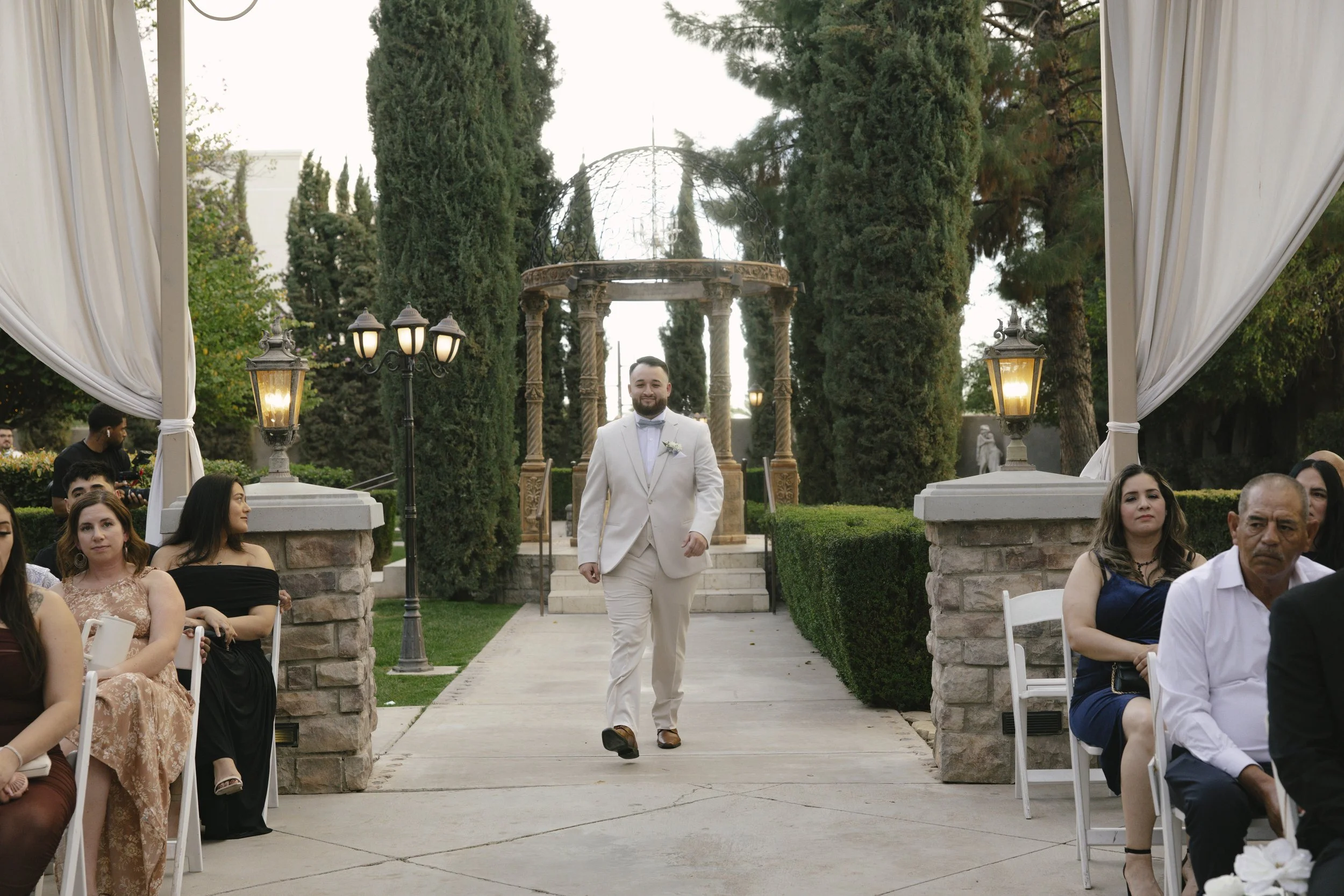 The wedding processional at Ashley Castle in Chandler, Arizona, was captured through hybrid film and digital photography, preserving the graceful entrances of the bridal party as they made their way through the romantic outdoor ceremony space surroun