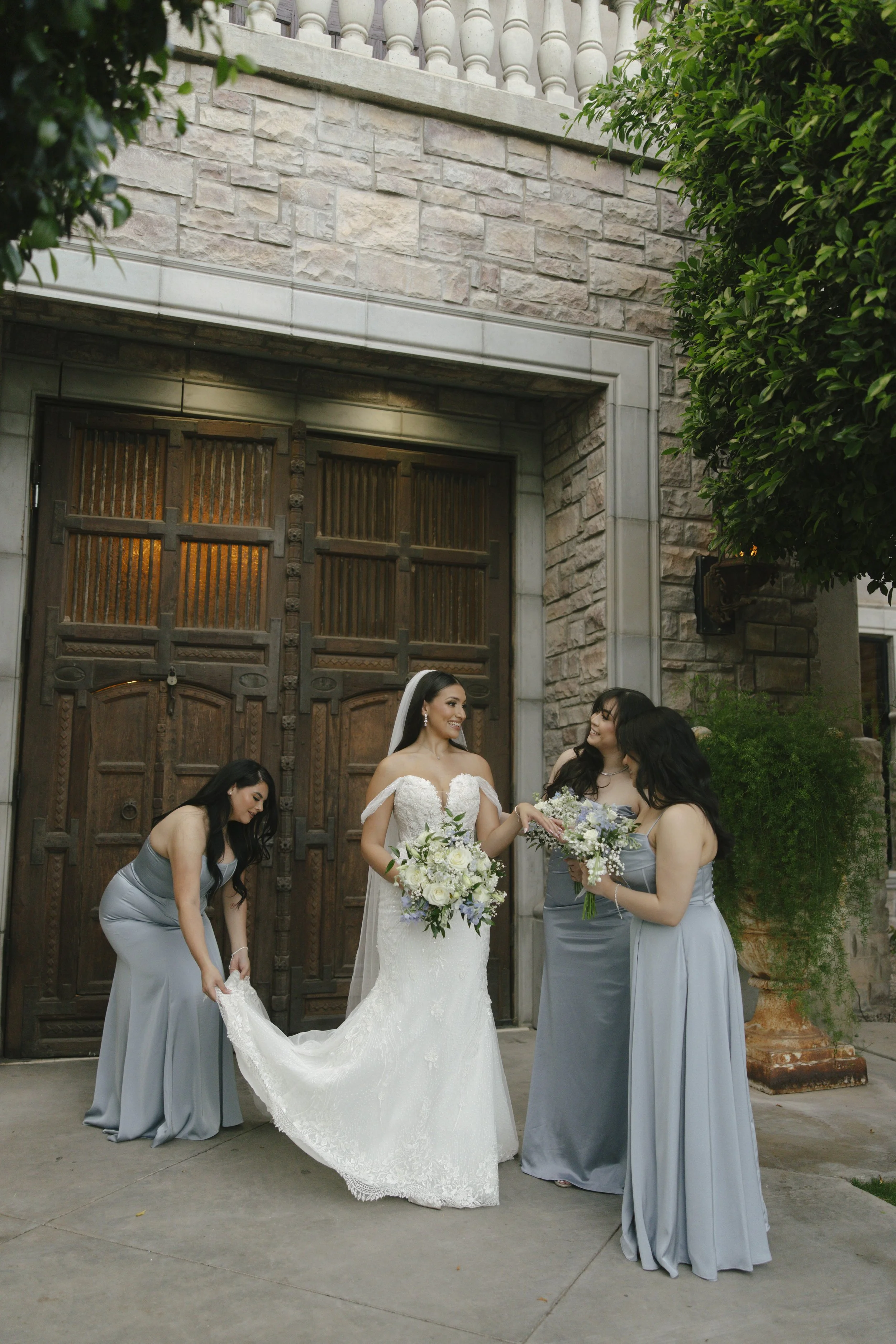 Bridal portraits at Ashley Castle in Chandler, Arizona, were captured through hybrid film and digital photography, showcasing the bride’s timeless elegance alongside her bridesmaids in the castle’s romantic courtyard gardens with soft evening light a