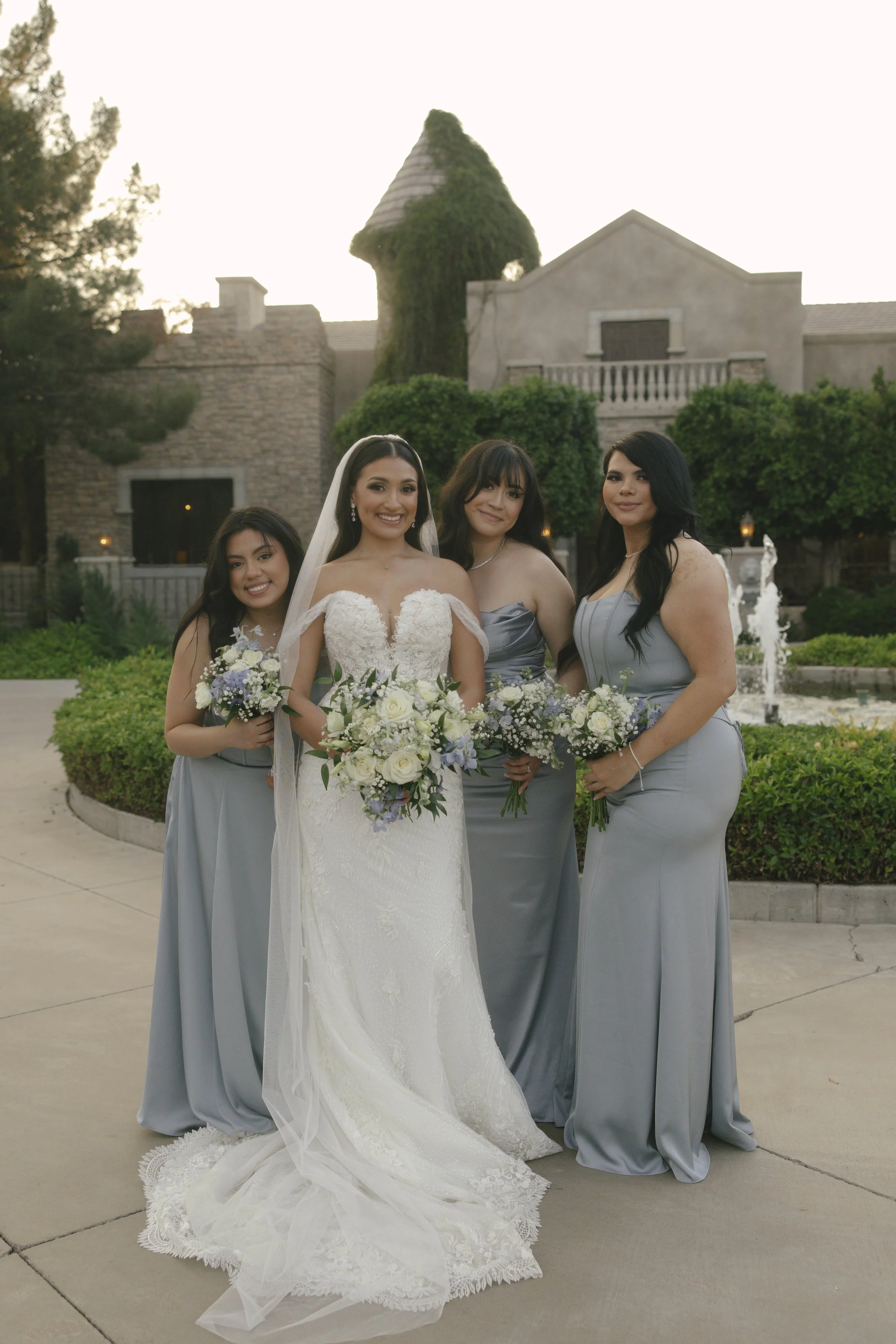Bridal portraits at Ashley Castle in Chandler, Arizona, were captured through hybrid film and digital photography, showcasing the bride’s timeless elegance alongside her bridesmaids in the castle’s romantic courtyard gardens with soft evening light a