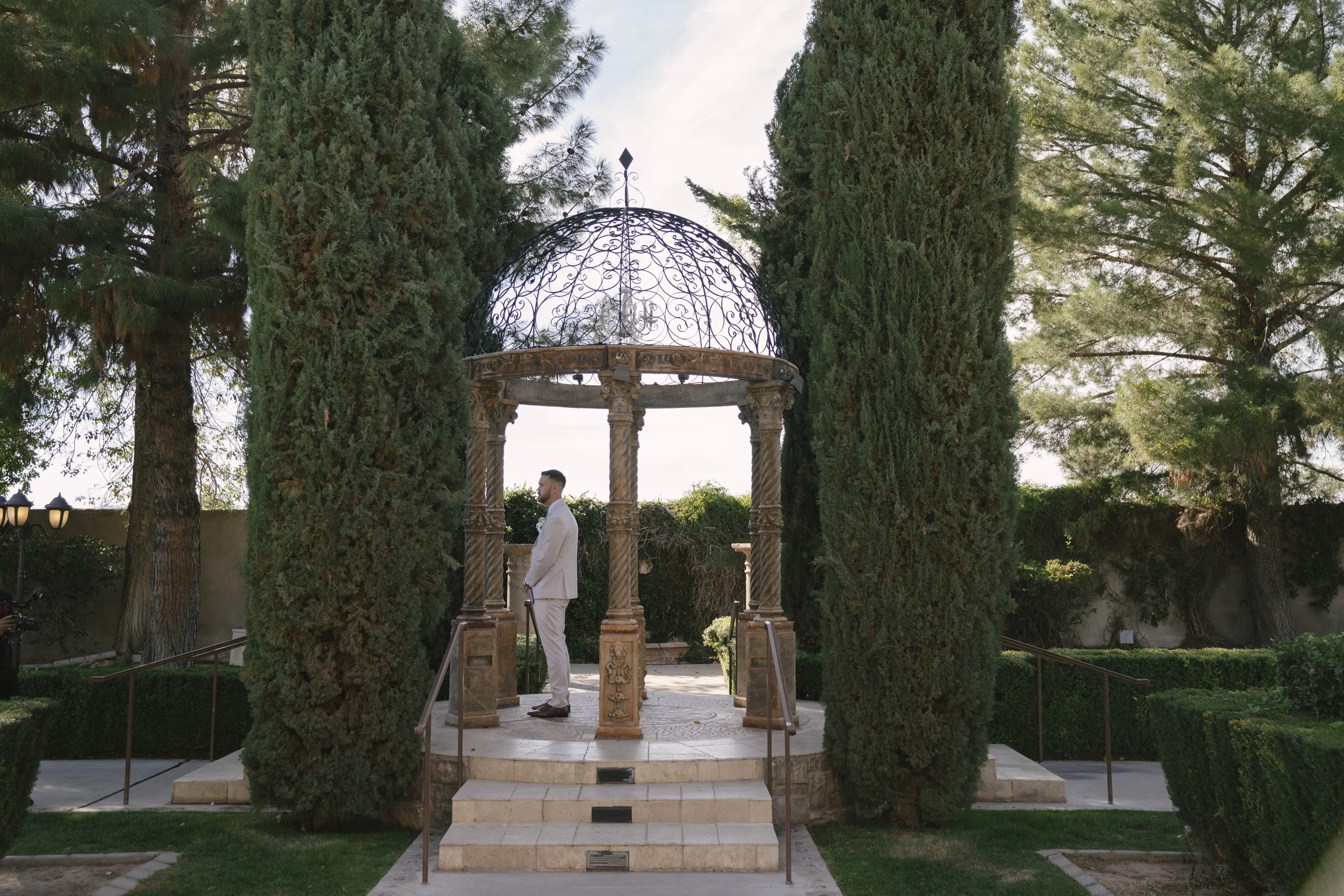 The bride and groom’s first look at Ashley Castle in Chandler, Arizona, unfolded in the venue’s romantic garden gazebo, where hybrid film and digital photography captured their emotional private reveal with timeless elegance, natural light, and intim