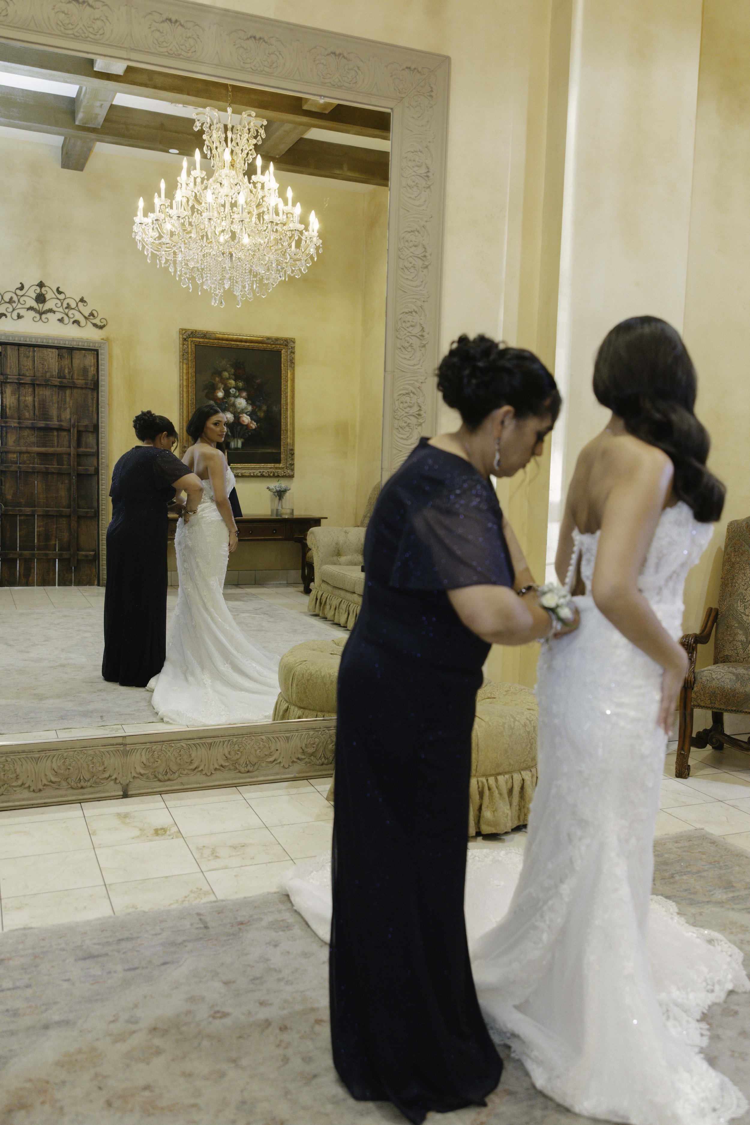 The bride’s final getting-ready moments at Ashley Castle in Chandler, Arizona, were captured through hybrid film and digital photography, preserving the intimate details of dress fastening, veil placement, and bridal finishing touches with timeless e
