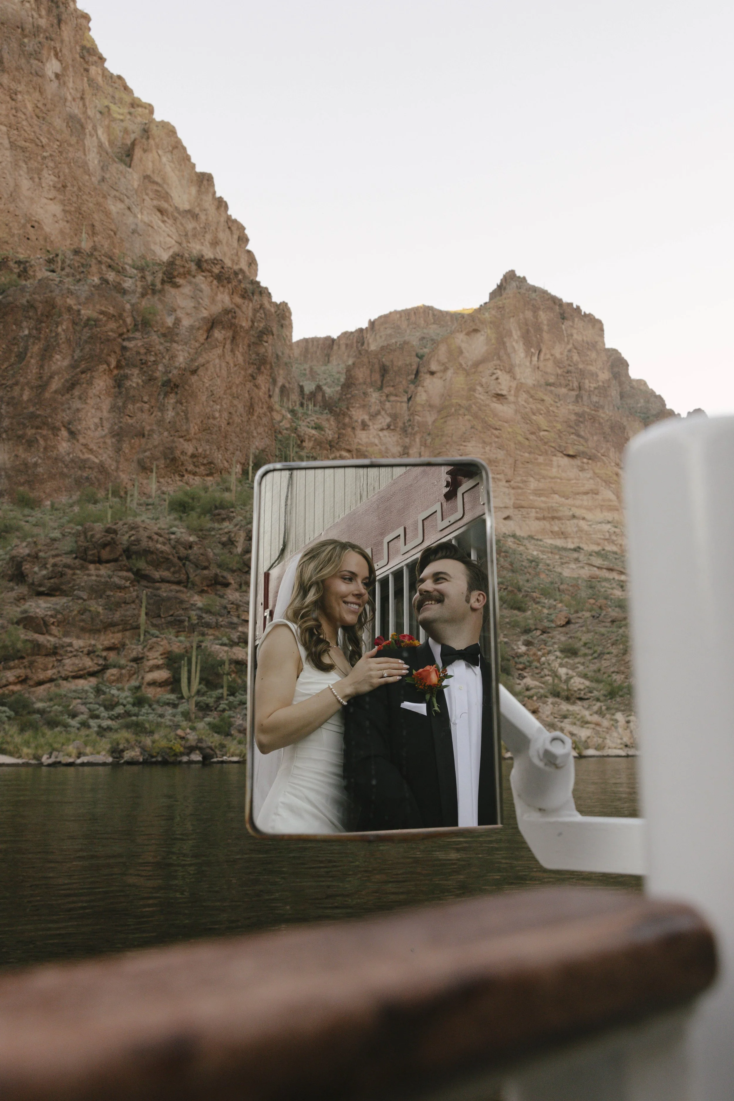 As the sun began to set over Canyon Lake, the couple stepped onto the deck of the Dolly Steamboat for golden hour portraits. With warm Arizona light reflecting off the water and desert mountains surrounding them, these quiet moments captured the beau