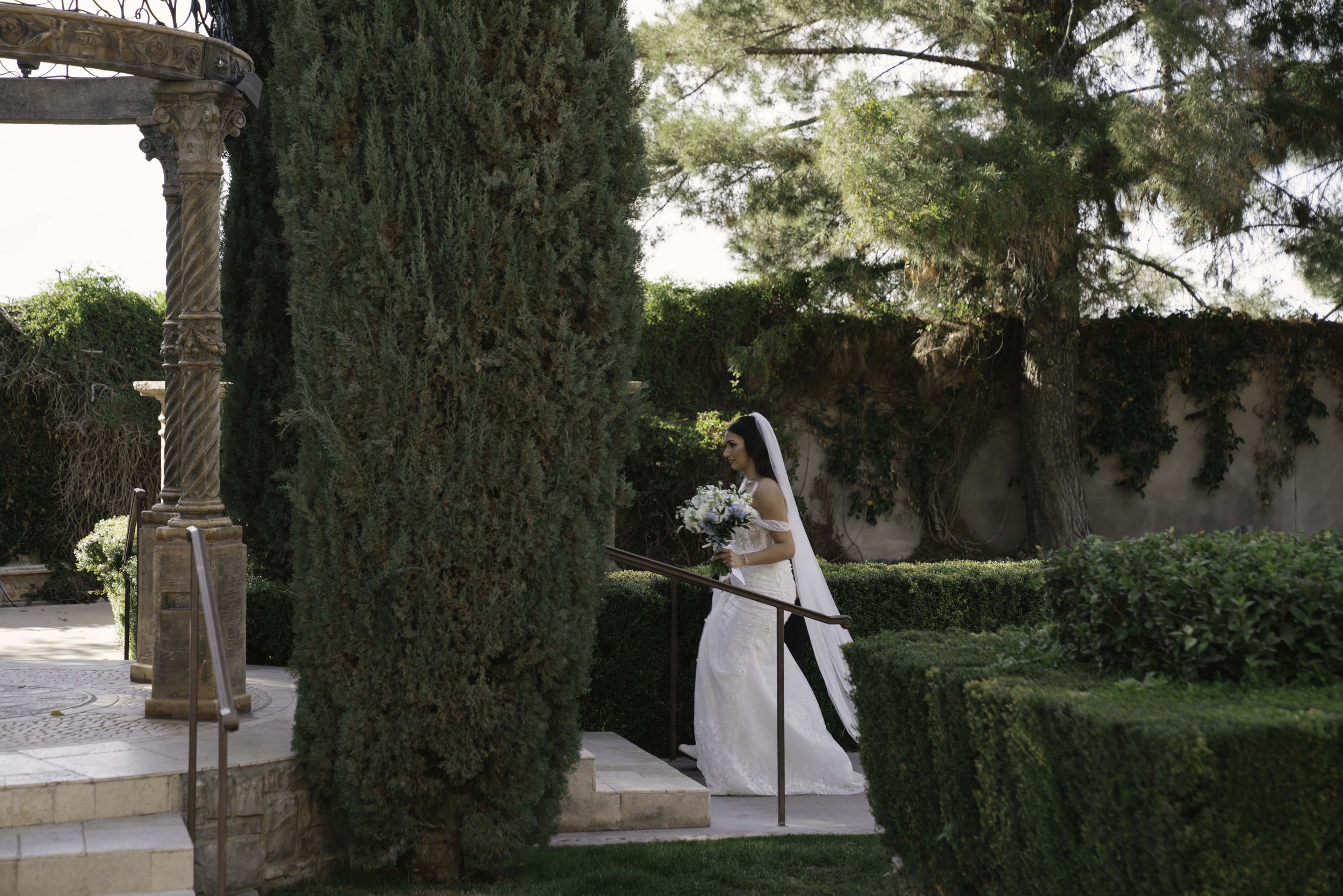 The bride and groom’s first look at Ashley Castle in Chandler, Arizona, unfolded in the venue’s romantic garden gazebo, where hybrid film and digital photography captured their emotional private reveal with timeless elegance, natural light, and intim