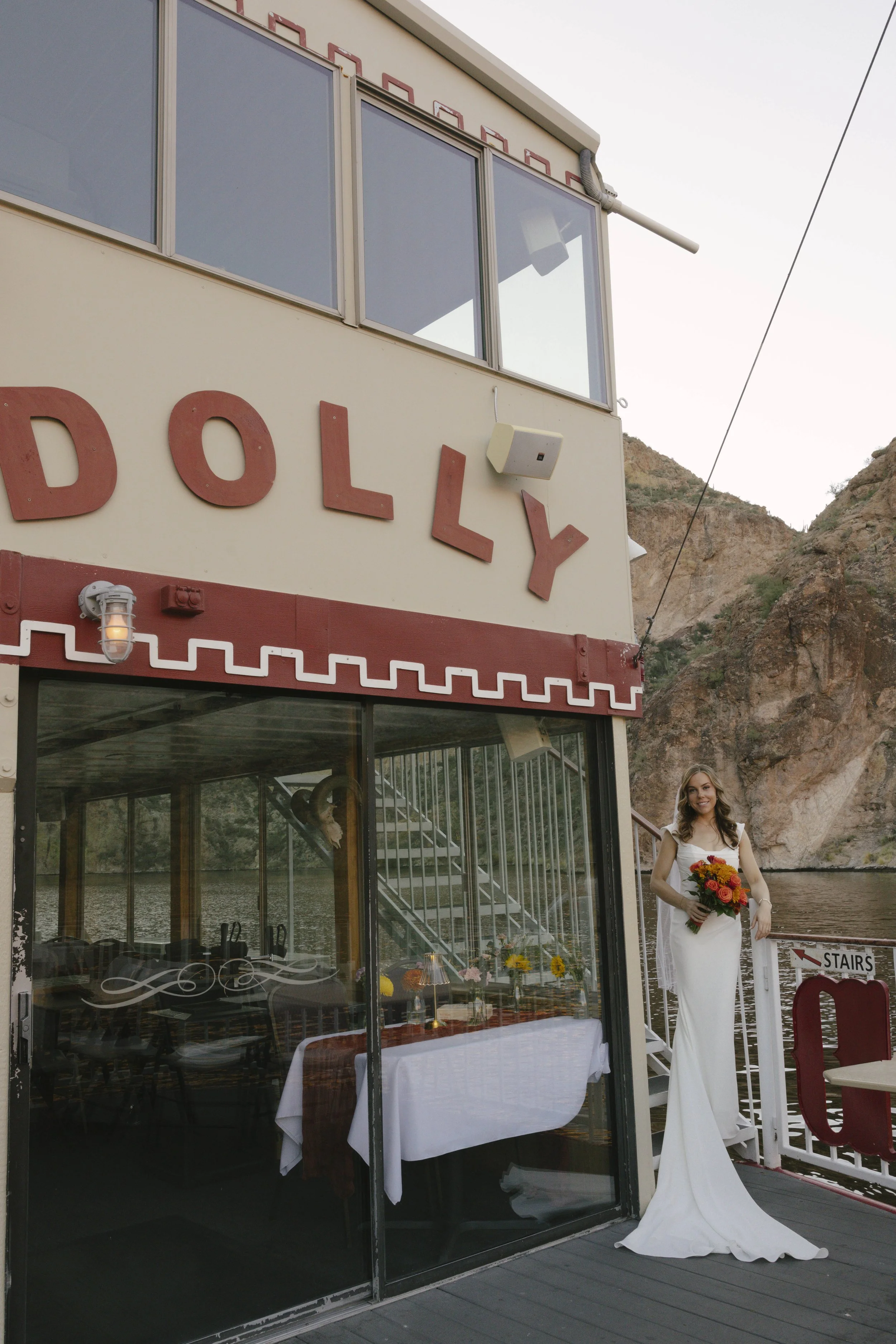 As the sun began to set over Canyon Lake, the couple stepped onto the deck of the Dolly Steamboat for golden hour portraits. With warm Arizona light reflecting off the water and desert mountains surrounding them, these quiet moments captured the beau