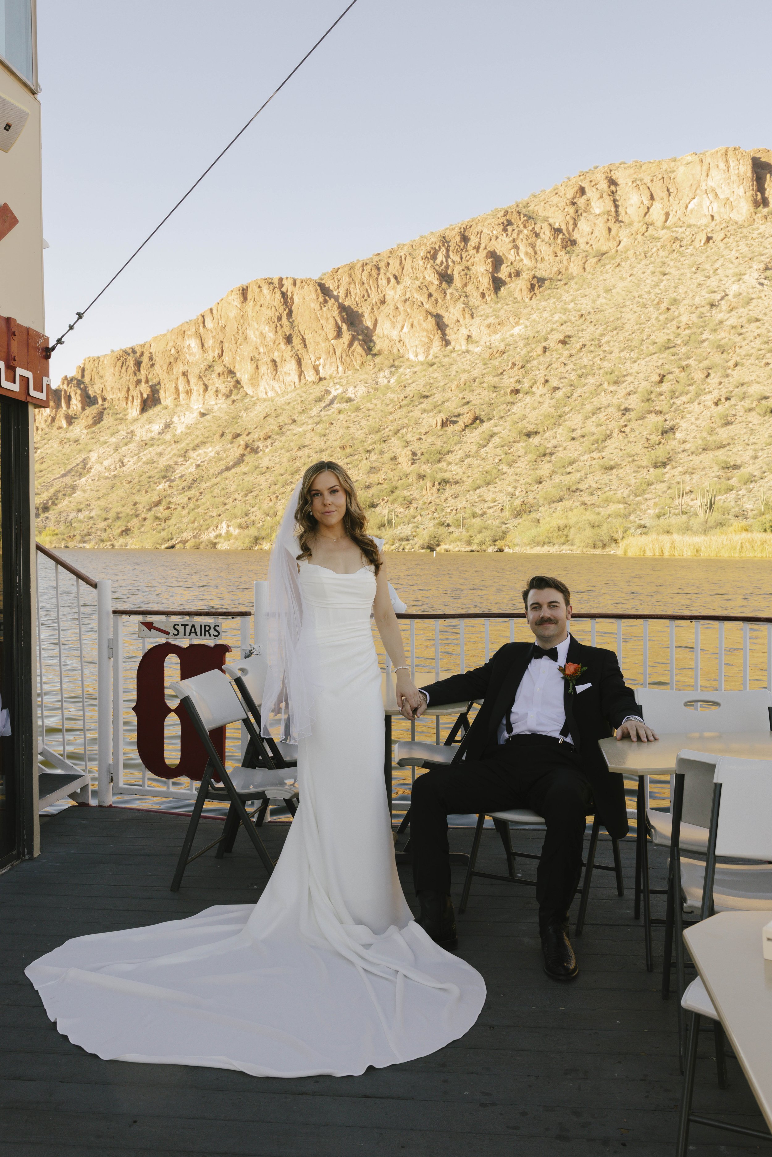 As the Dolly Steamboat cruised through Canyon Lake, guests enjoyed an intimate reception surrounded by Arizona’s desert mountains and open water. The tables were beautifully set with warm tones, fresh florals, and thoughtful details that complemented