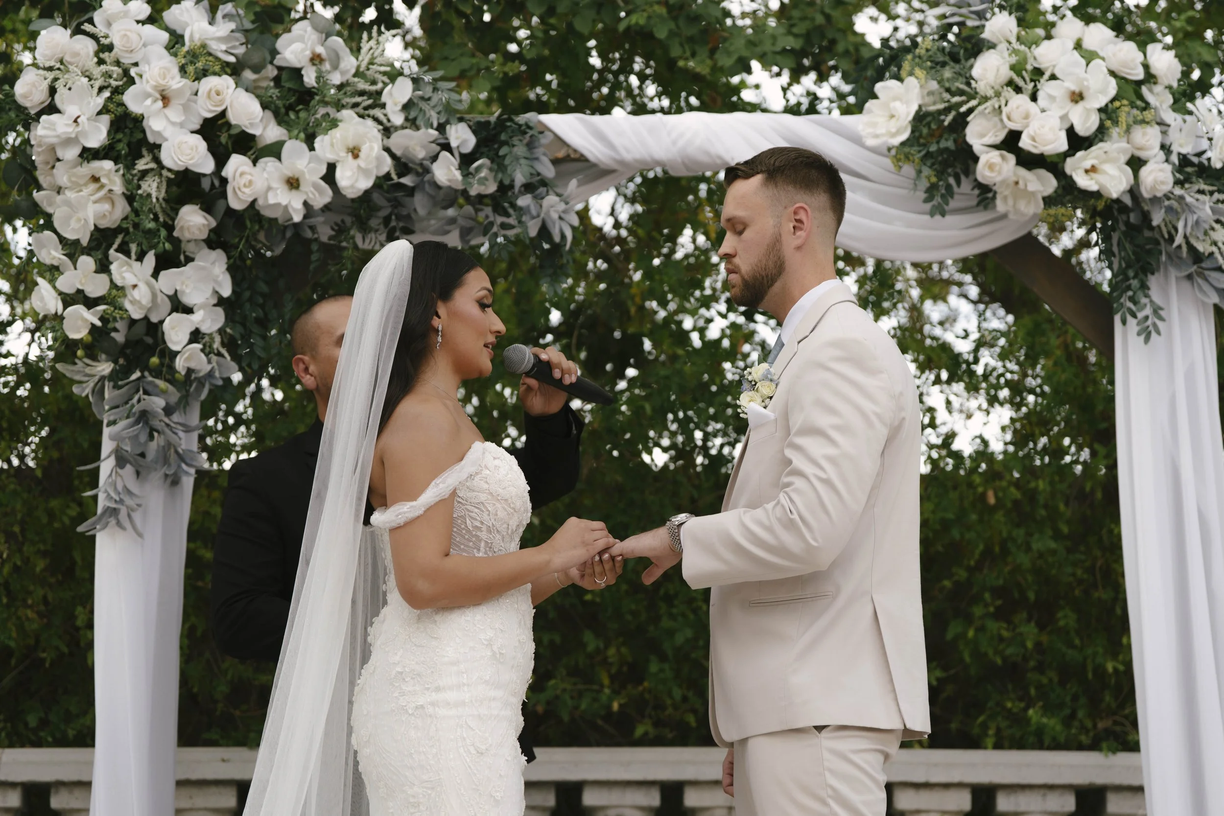 The bride and groom’s ceremony at Ashley Castle in Chandler, Arizona, was beautifully documented through hybrid film and digital photography, capturing their vows, ring exchange, and heartfelt moments beneath a romantic floral altar in the castle’s e