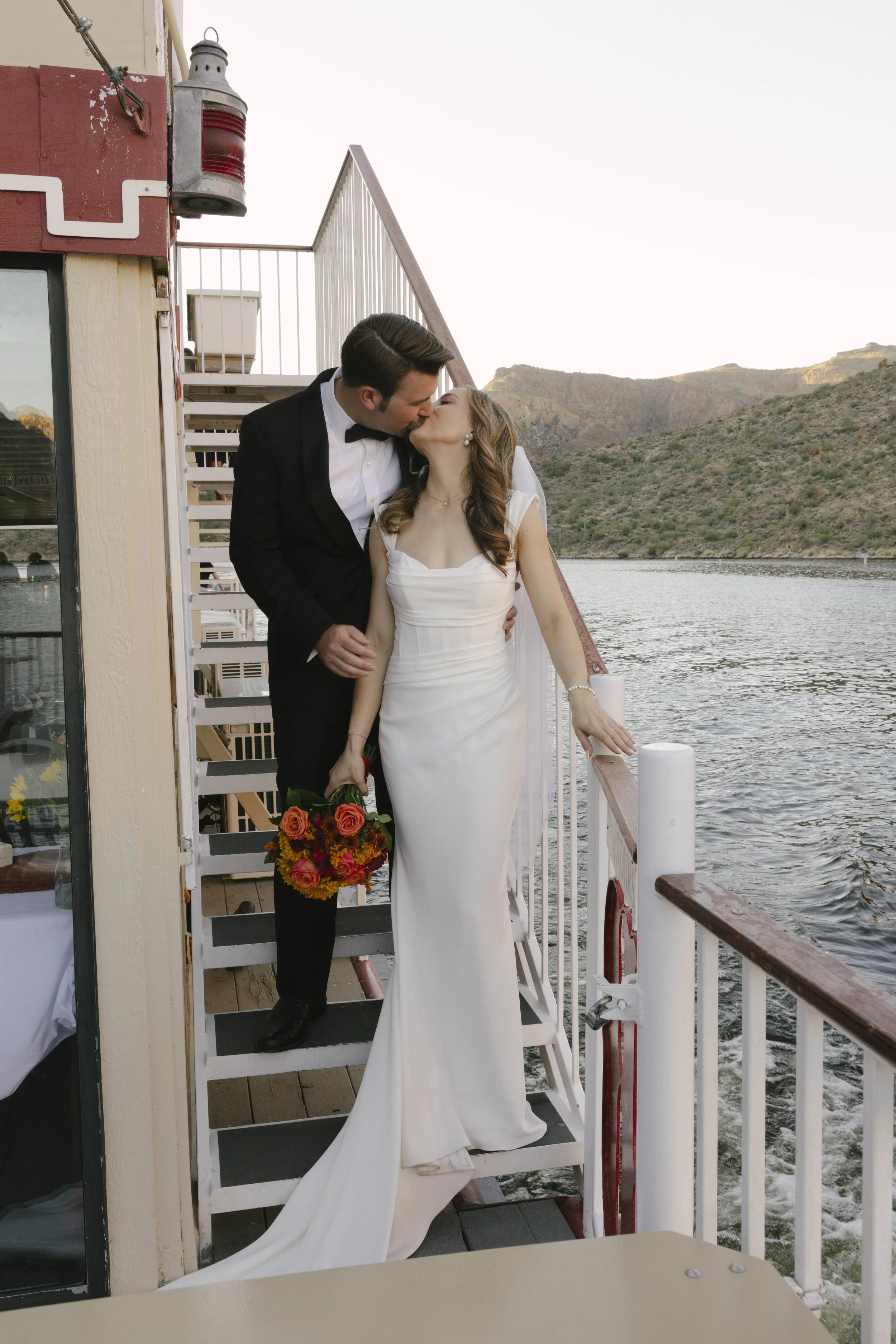 As the sun began to set over Canyon Lake, the couple stepped onto the deck of the Dolly Steamboat for golden hour portraits. With warm Arizona light reflecting off the water and desert mountains surrounding them, these quiet moments captured the beau