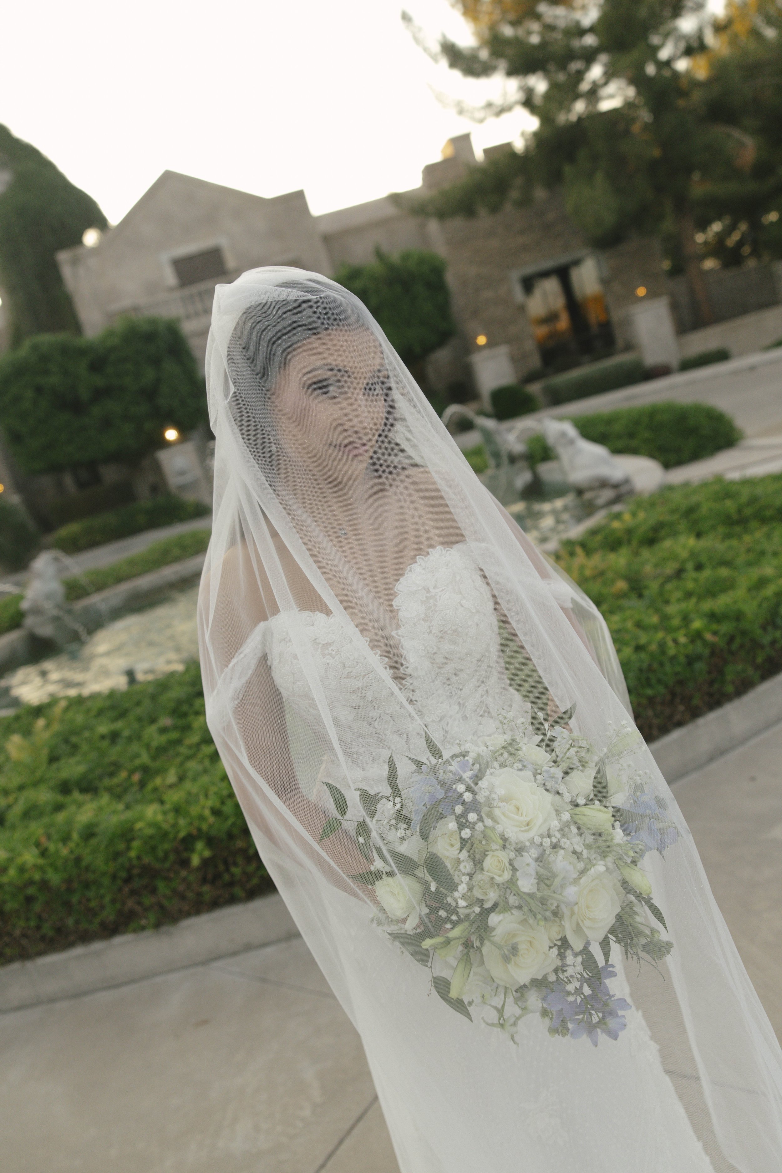 Bridal portraits at Ashley Castle in Chandler, Arizona, were captured through hybrid film and digital photography, showcasing the bride’s timeless elegance alongside her bridesmaids in the castle’s romantic courtyard gardens with soft evening light a