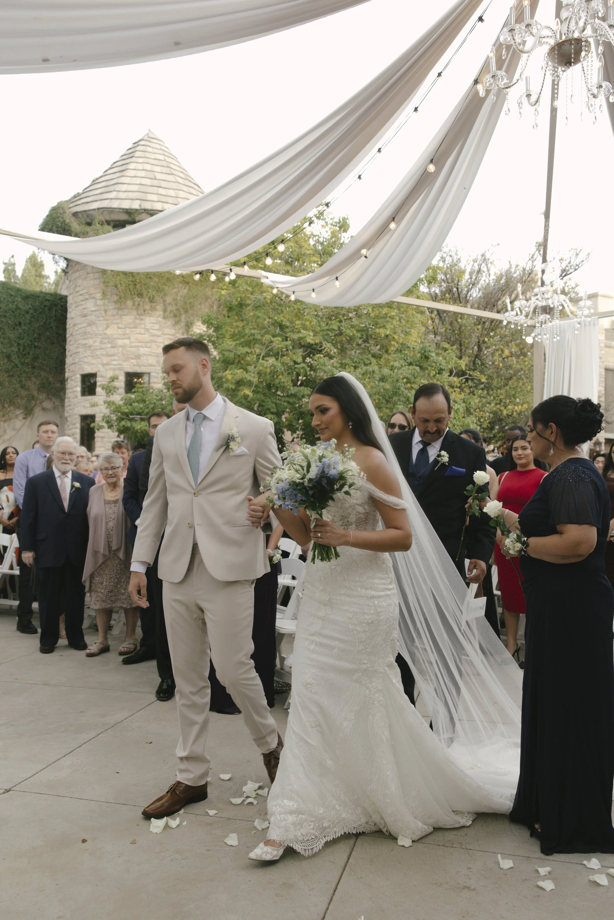The wedding processional at Ashley Castle in Chandler, Arizona, was captured through hybrid film and digital photography, preserving the graceful entrances of the bridal party as they made their way through the romantic outdoor ceremony space surroun