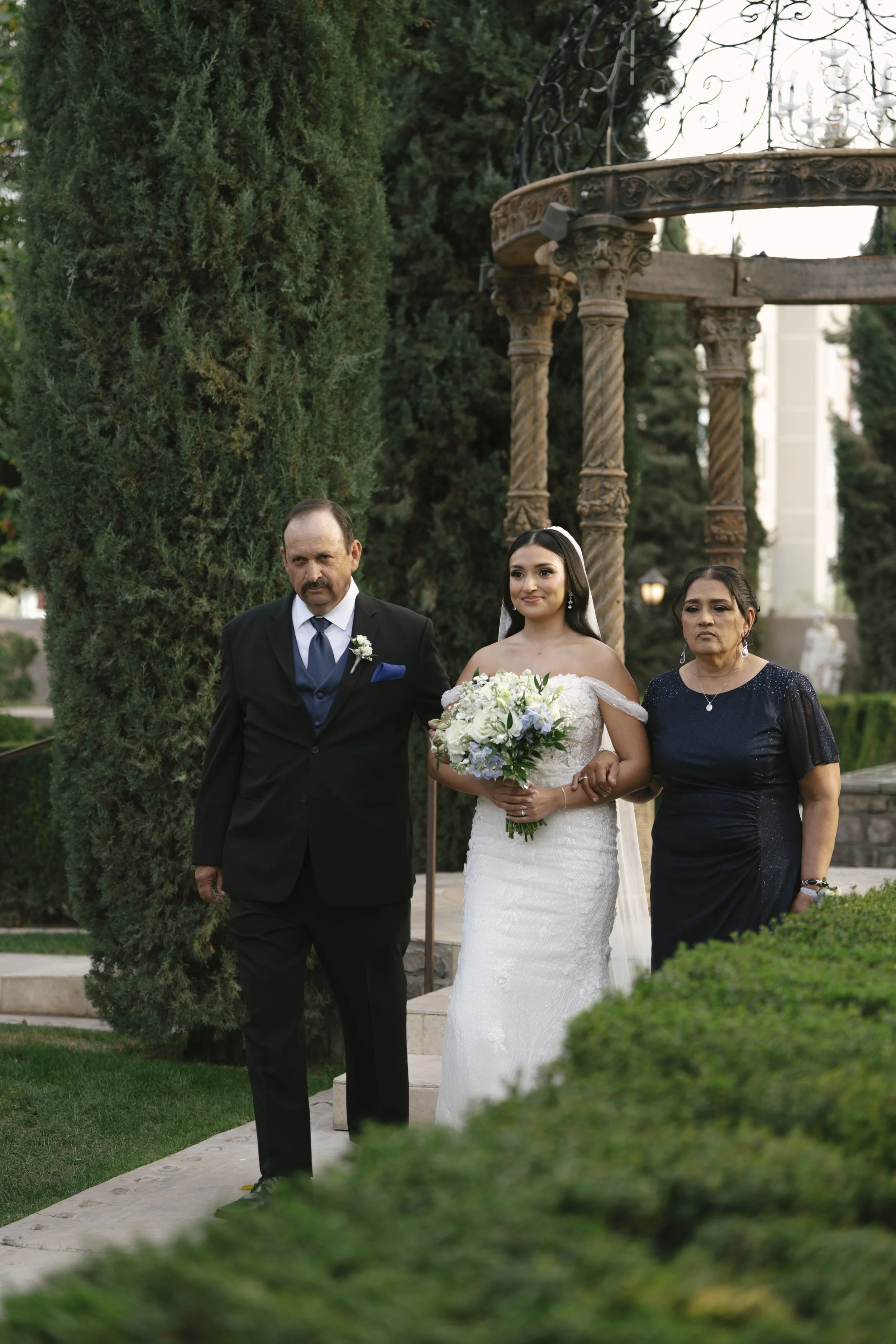 The wedding processional at Ashley Castle in Chandler, Arizona, was captured through hybrid film and digital photography, preserving the graceful entrances of the bridal party as they made their way through the romantic outdoor ceremony space surroun