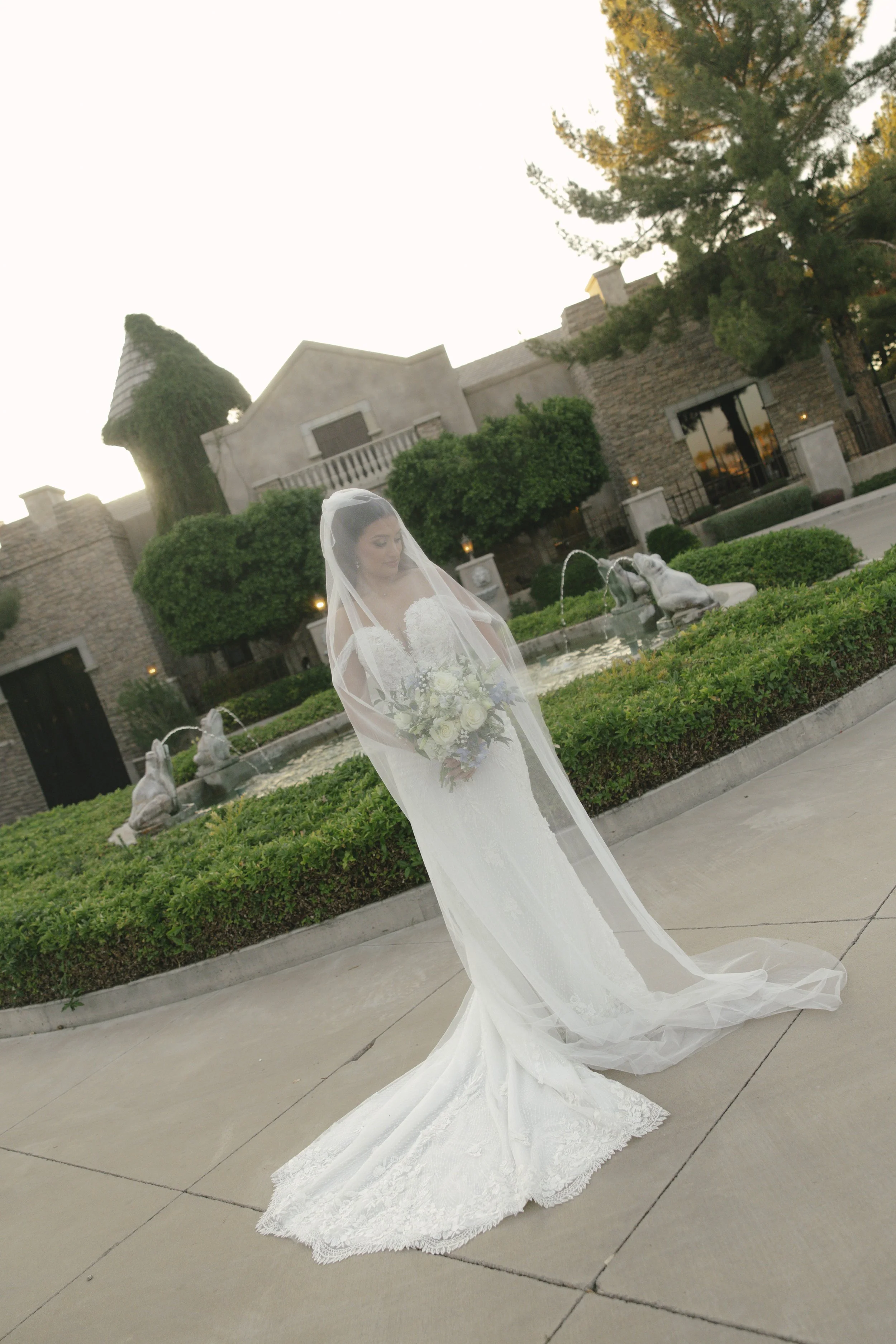 The bride’s solo portraits at Ashley Castle in Chandler, Arizona, were captured through hybrid film and digital photography, highlighting timeless bridal elegance with romantic veil details, graceful movement, and the castle’s stunning courtyard and 