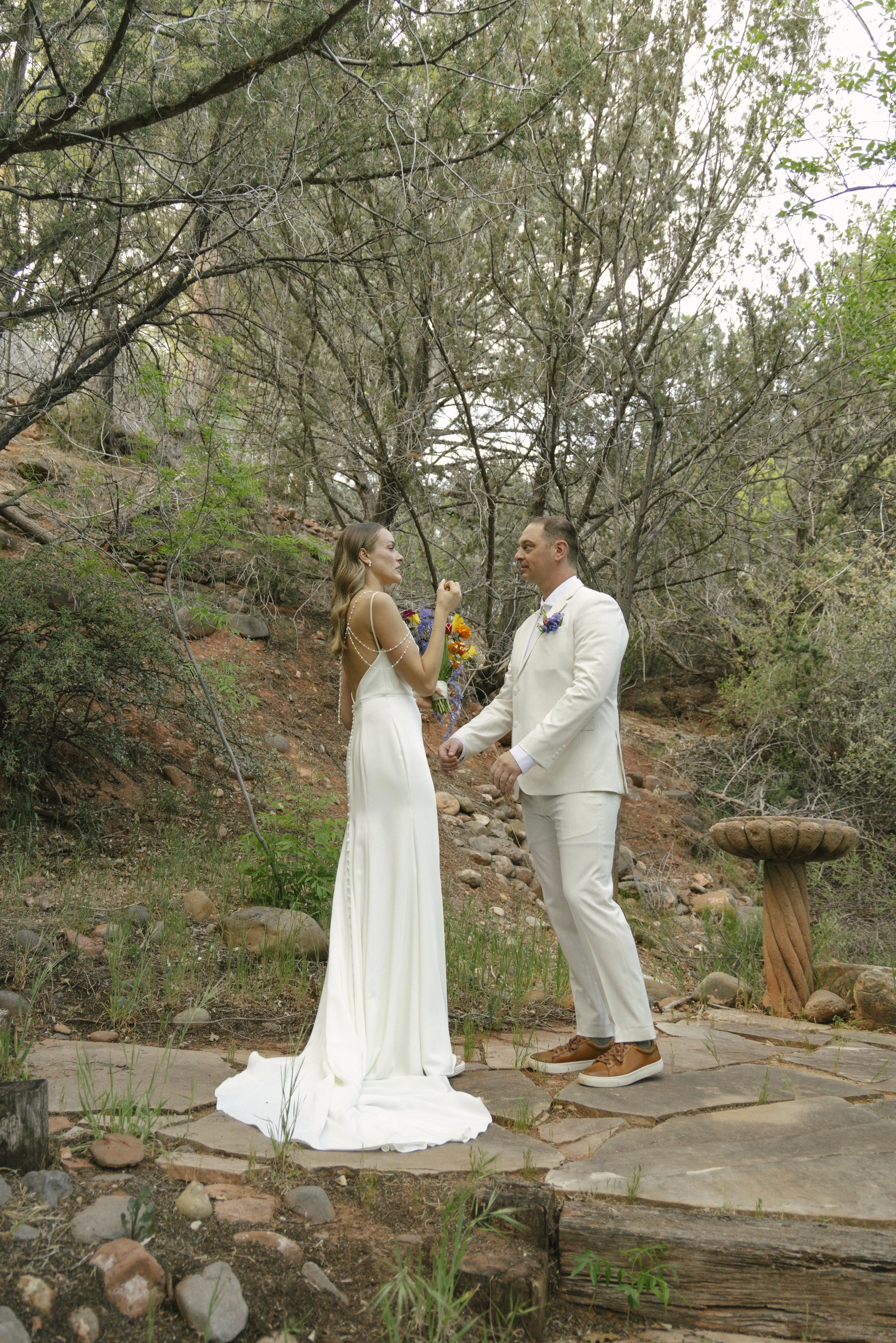 Chelsea and Travis shared an intimate first look surrounded by the natural beauty of Sedona before exchanging vows during their private Arizona elopement ceremony. Set along a peaceful garden path, these heartfelt moments marked the beginning of thei