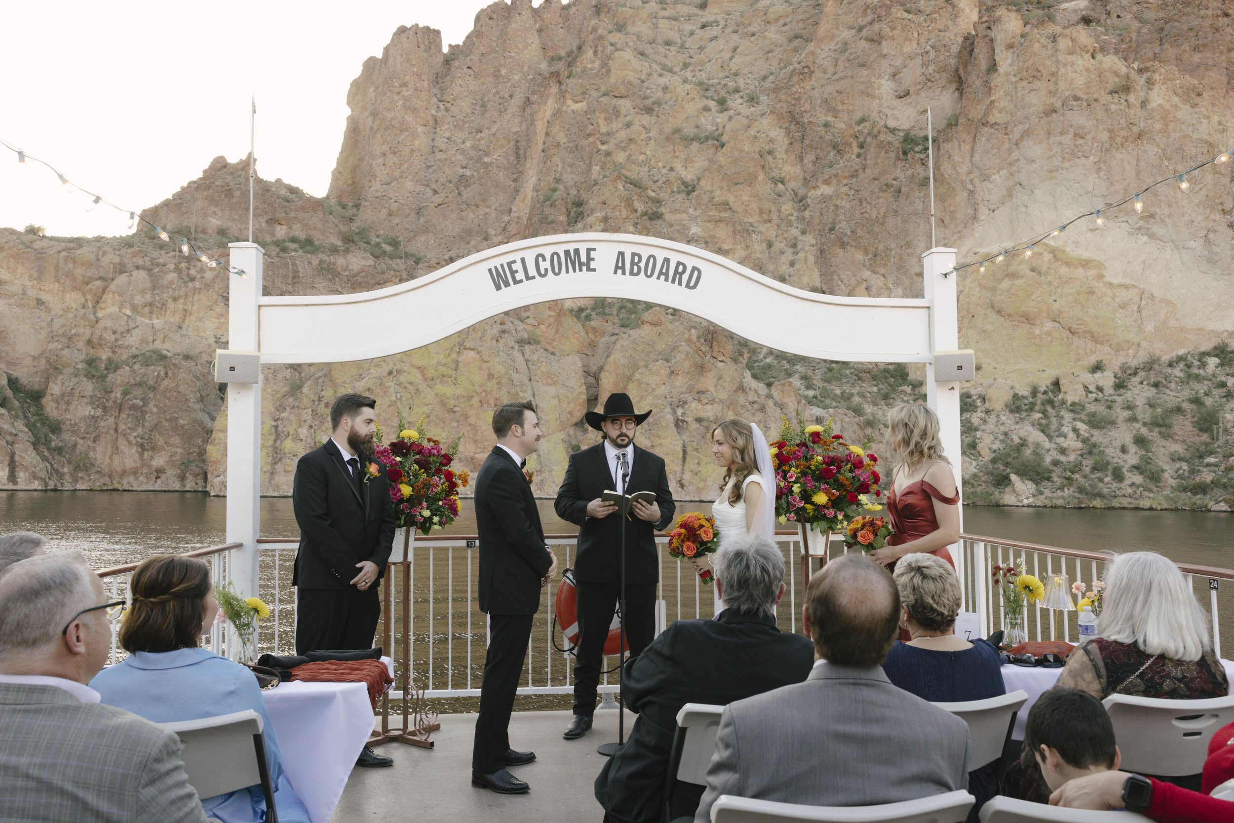With Canyon Lake’s towering desert cliffs surrounding them, the couple exchanged rings and said “I do” aboard the Dolly Steamboat. Surrounded by about 60 of their closest friends and family, the ceremony took place on the deck with breathtaking Arizo