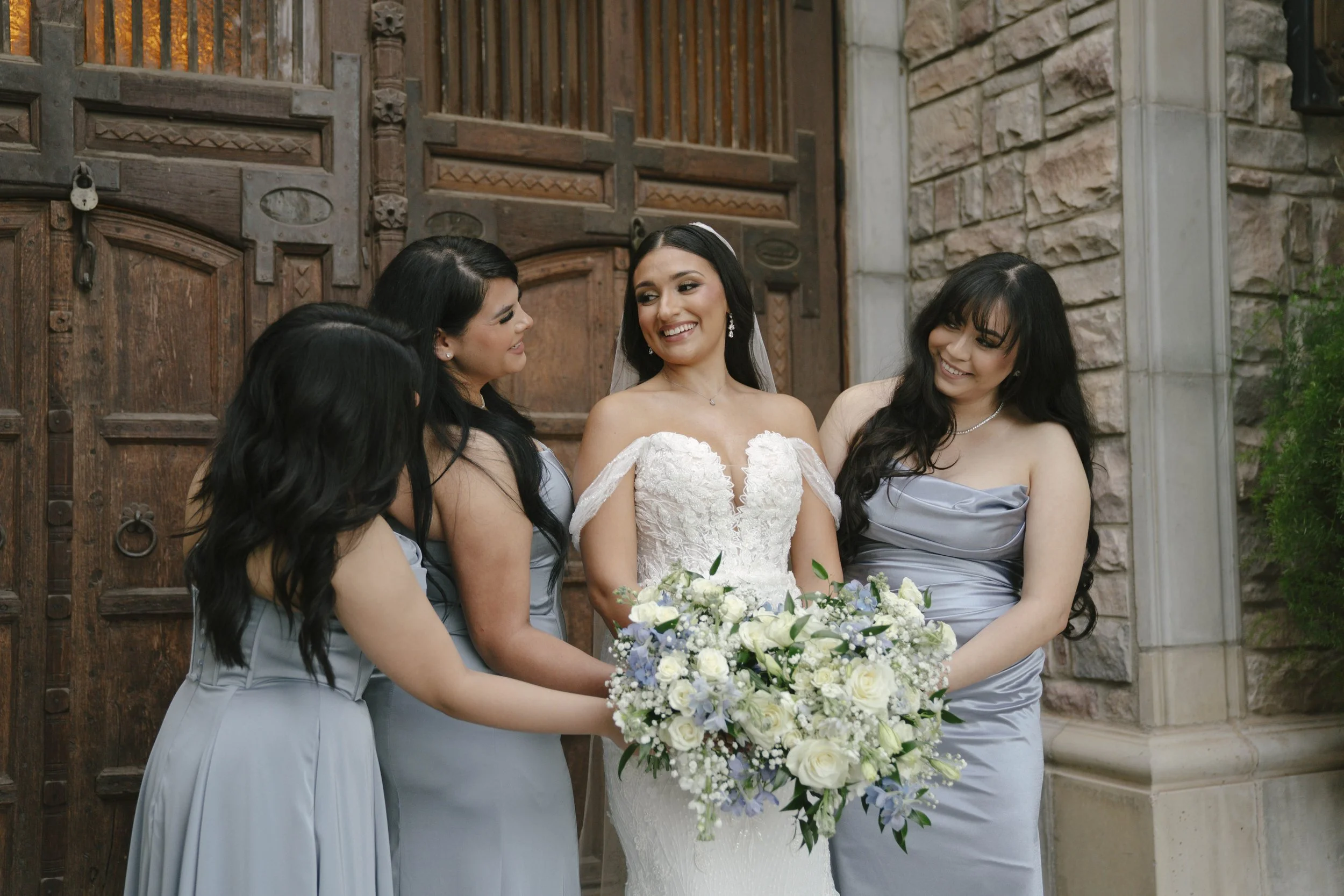 Bridal portraits at Ashley Castle in Chandler, Arizona, were captured through hybrid film and digital photography, showcasing the bride’s timeless elegance alongside her bridesmaids in the castle’s romantic courtyard gardens with soft evening light a