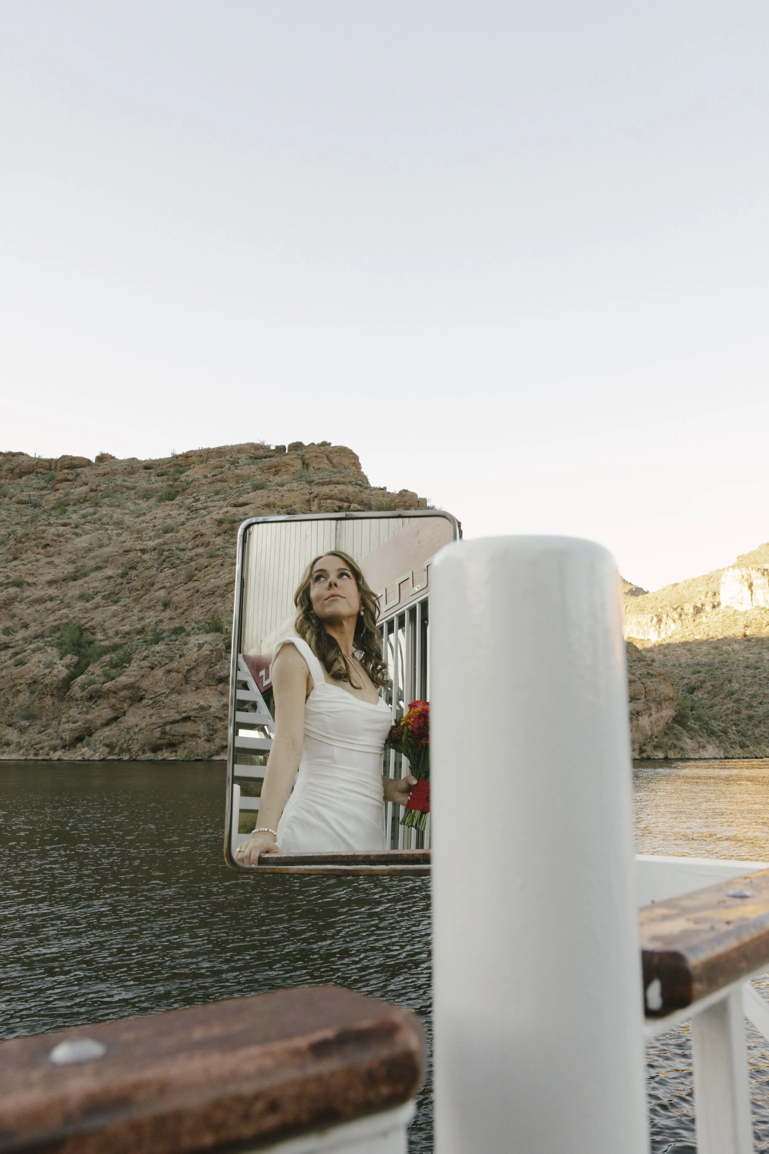 As the sun began to set over Canyon Lake, the couple stepped onto the deck of the Dolly Steamboat for golden hour portraits. With warm Arizona light reflecting off the water and desert mountains surrounding them, these quiet moments captured the beau
