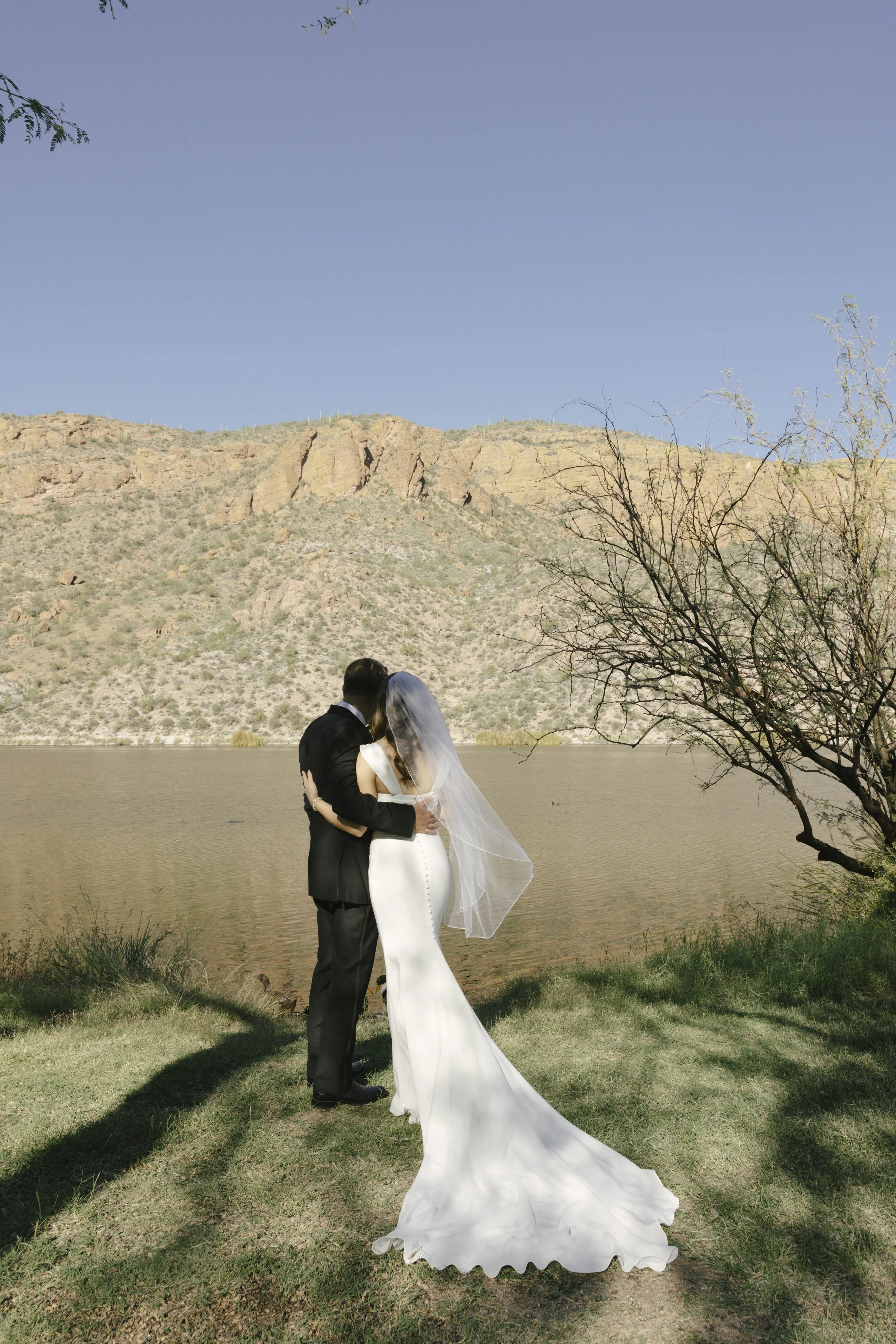 Before boarding the Dolly Steamboat, the couple shared a quiet first look along the shoreline of Canyon Lake. Surrounded by the desert mountains and calm water, they exchanged private vows in an intimate moment before the celebration began. The peace