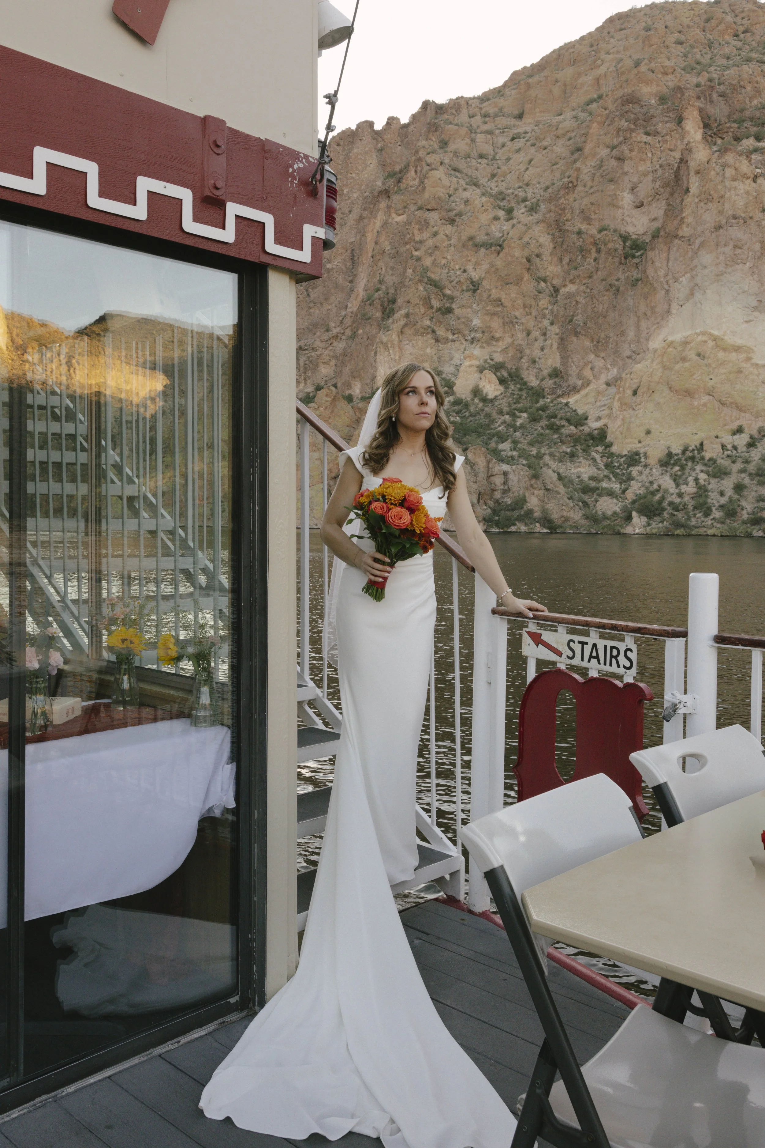 As the sun began to set over Canyon Lake, the couple stepped onto the deck of the Dolly Steamboat for golden hour portraits. With warm Arizona light reflecting off the water and desert mountains surrounding them, these quiet moments captured the beau