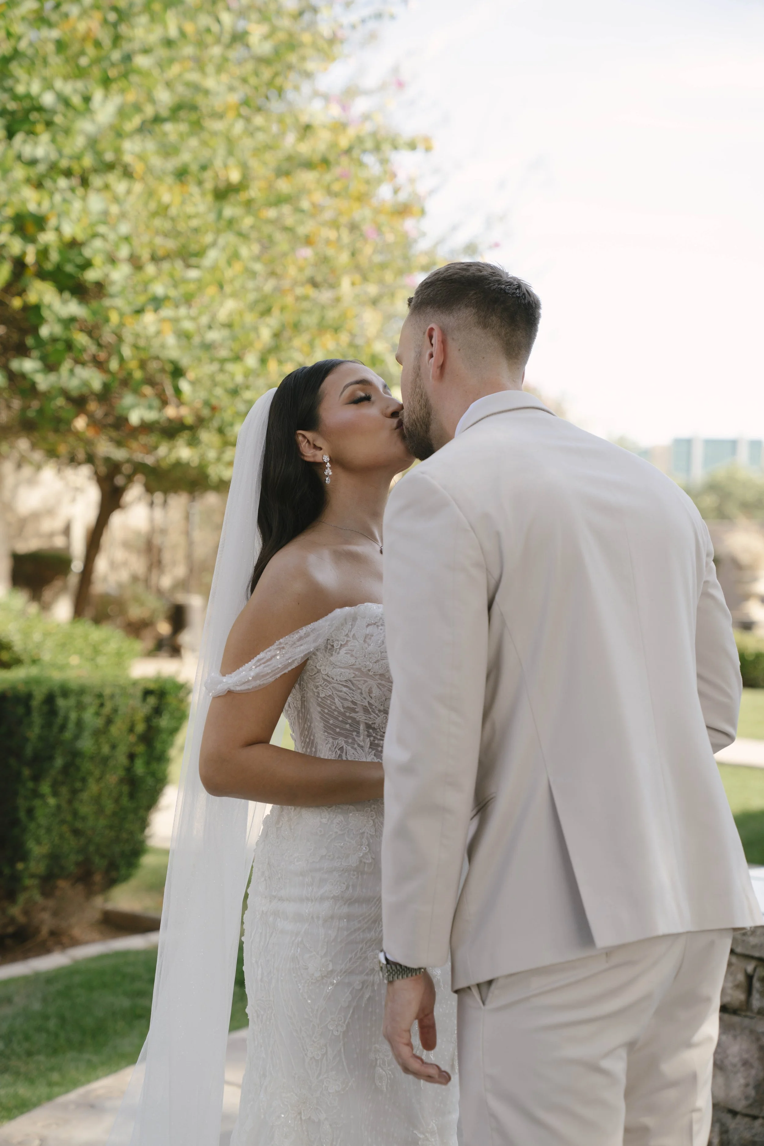 The bride and groom’s first look at Ashley Castle in Chandler, Arizona, unfolded in the venue’s romantic garden gazebo, where hybrid film and digital photography captured their emotional private reveal with timeless elegance, natural light, and intim